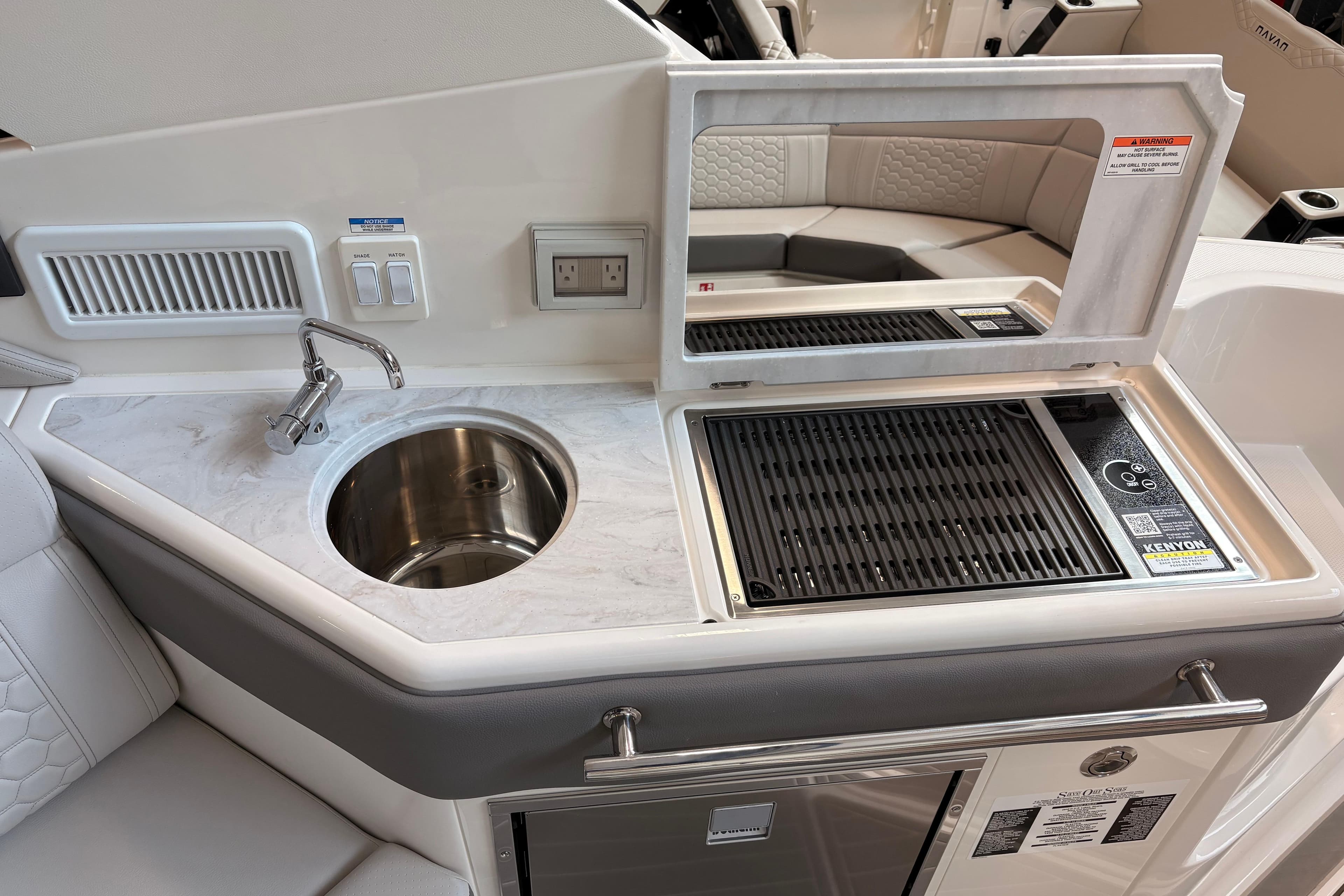 2026 Sea Ray Sundancer 320 yacht kitchenette with sink and grill, featuring modern design.
