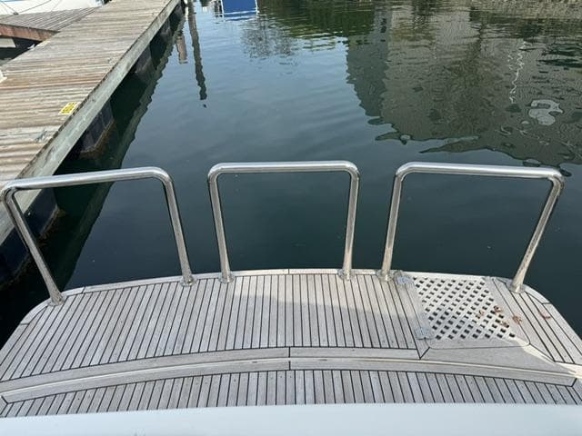 McKinna 57 Pilothouse 2000 yacht stern with wooden deck and metal railings.