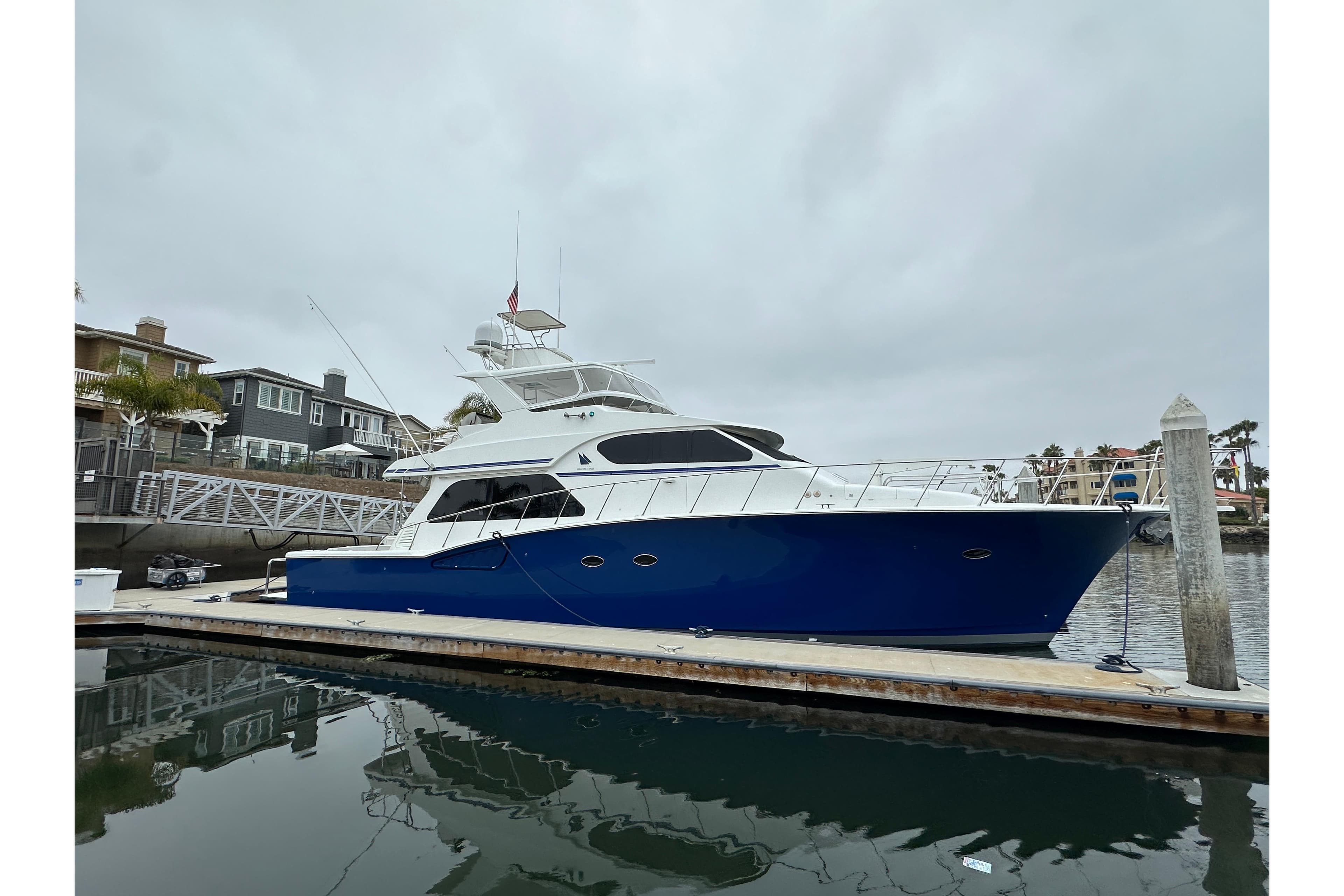 2004 Mikelson 61 PH yacht docked at marina, featuring sleek blue and white design.