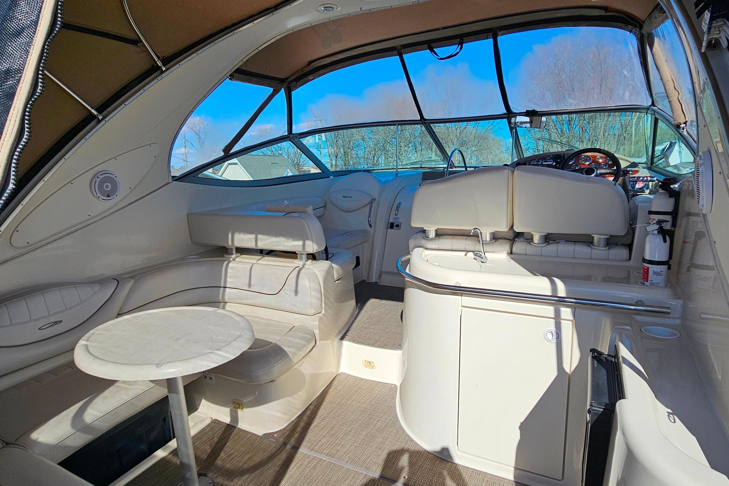 Interior of 2001 Maxum 3500 SCR boat with seating and helm, under clear blue sky.