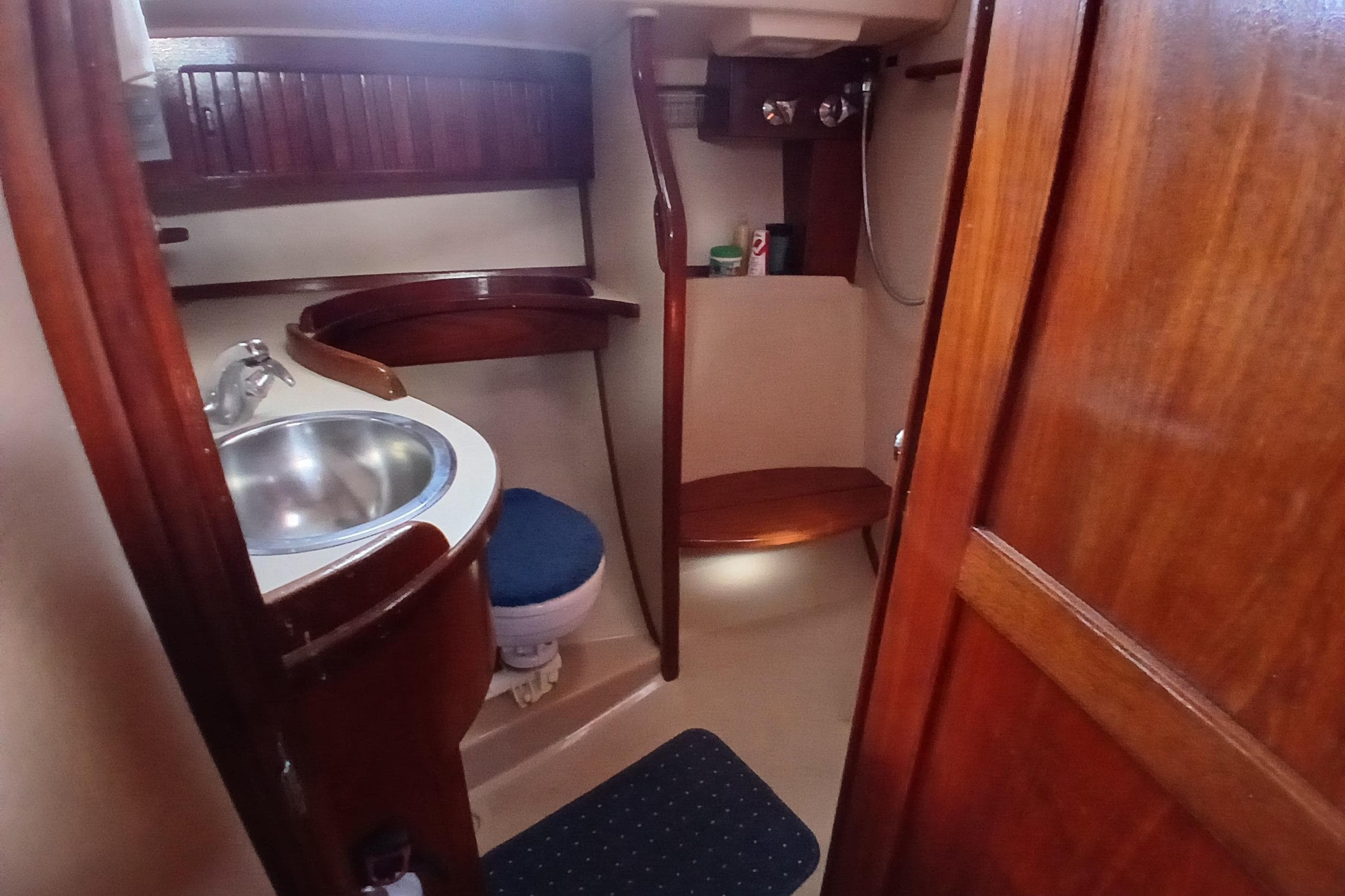 1995 Island Packet 37 yacht bathroom with wooden cabinetry and stainless steel sink.