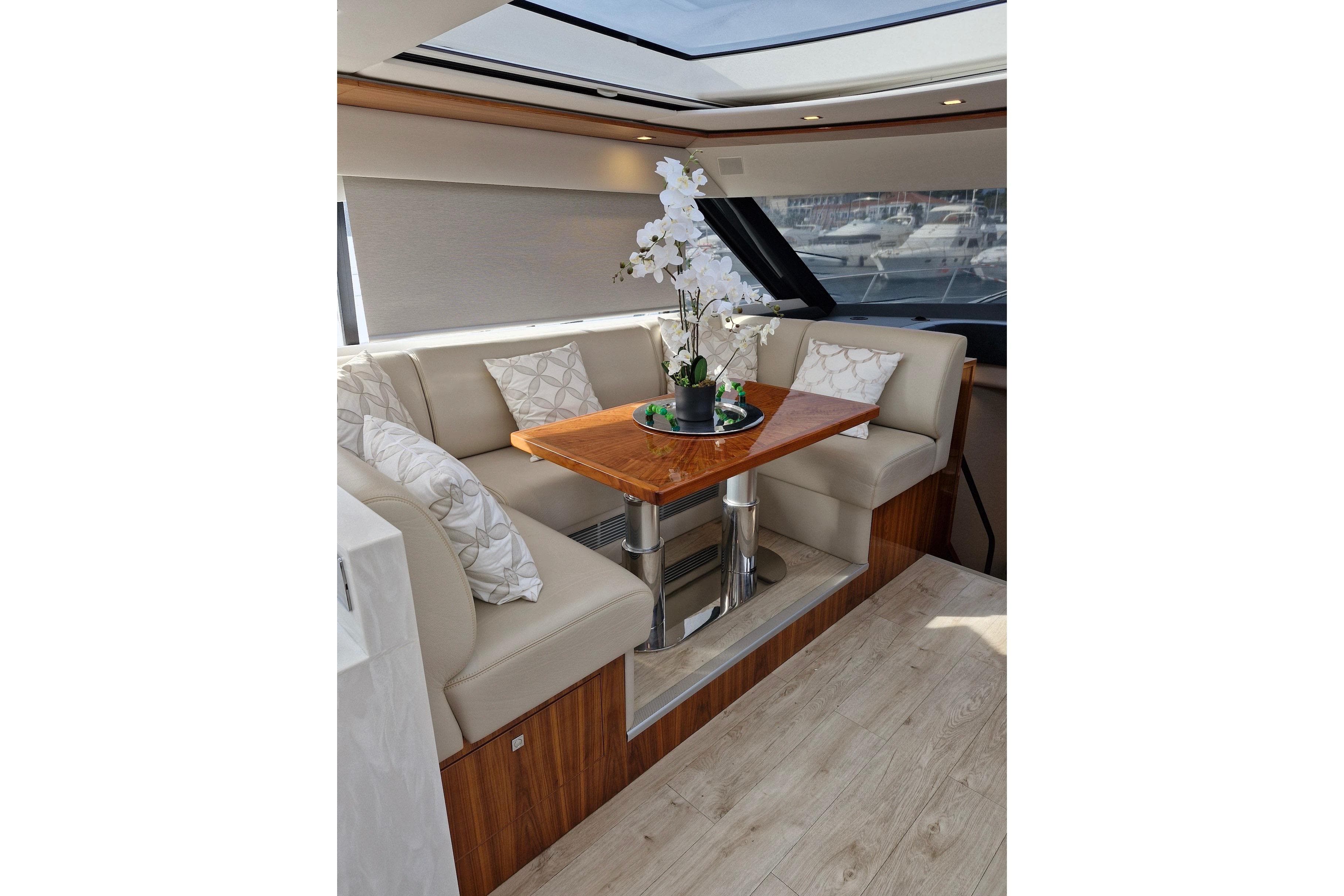 Luxurious interior of 2020 Riviera 6000 Sport Yacht Platinum Edition with elegant seating and table.