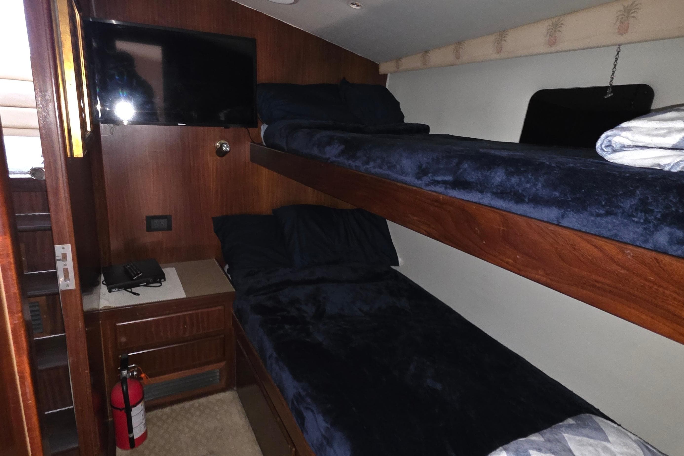 Interior cabin of 1989 Hatteras 52 Convertible with bunk beds and TV.
