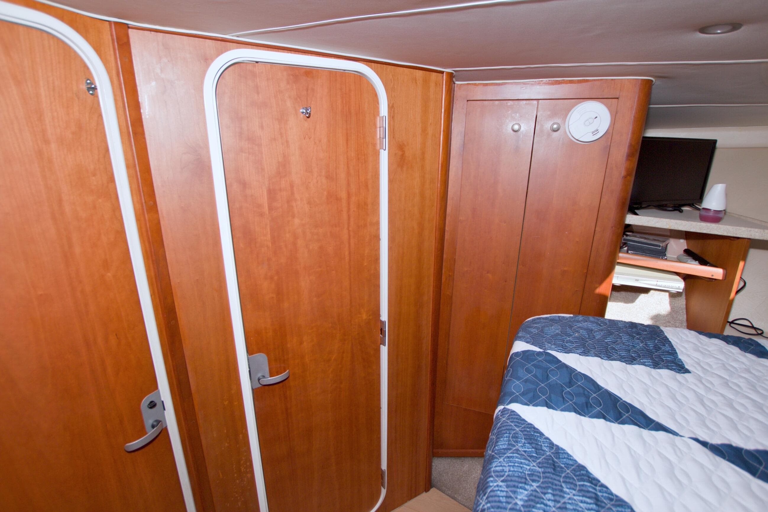 Interior of 1998 Luhrs 36 Convertible boat with wooden cabinetry and bed.