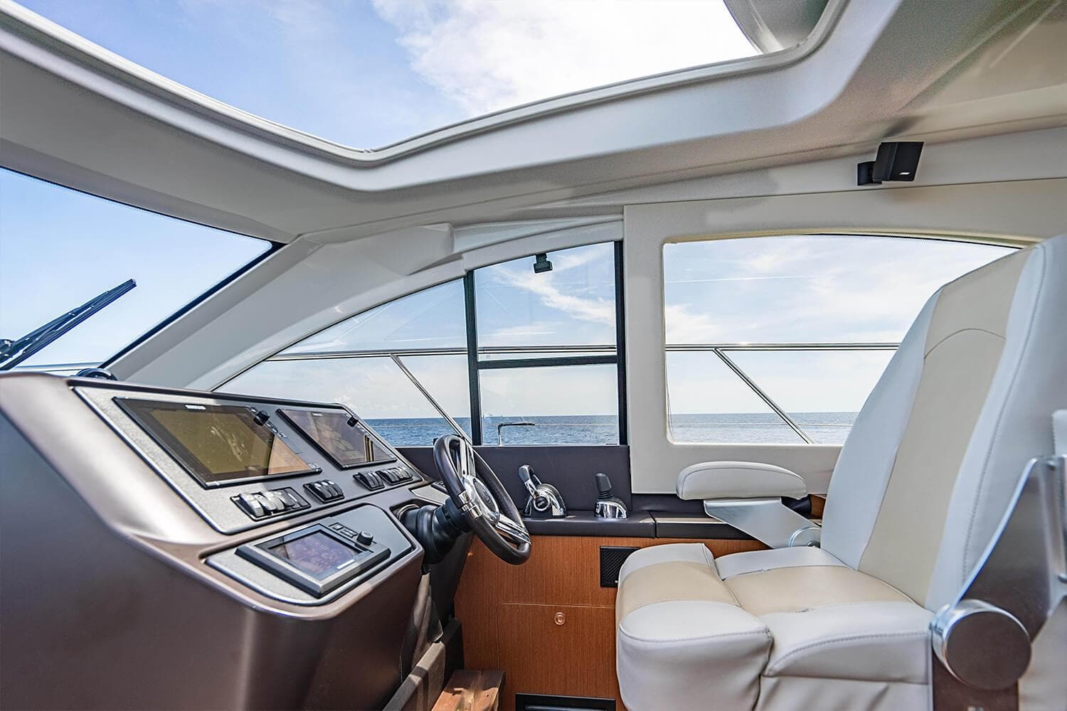 Interior of 2017 Beneteau Gran Turismo yacht, featuring modern helm and luxurious seating.