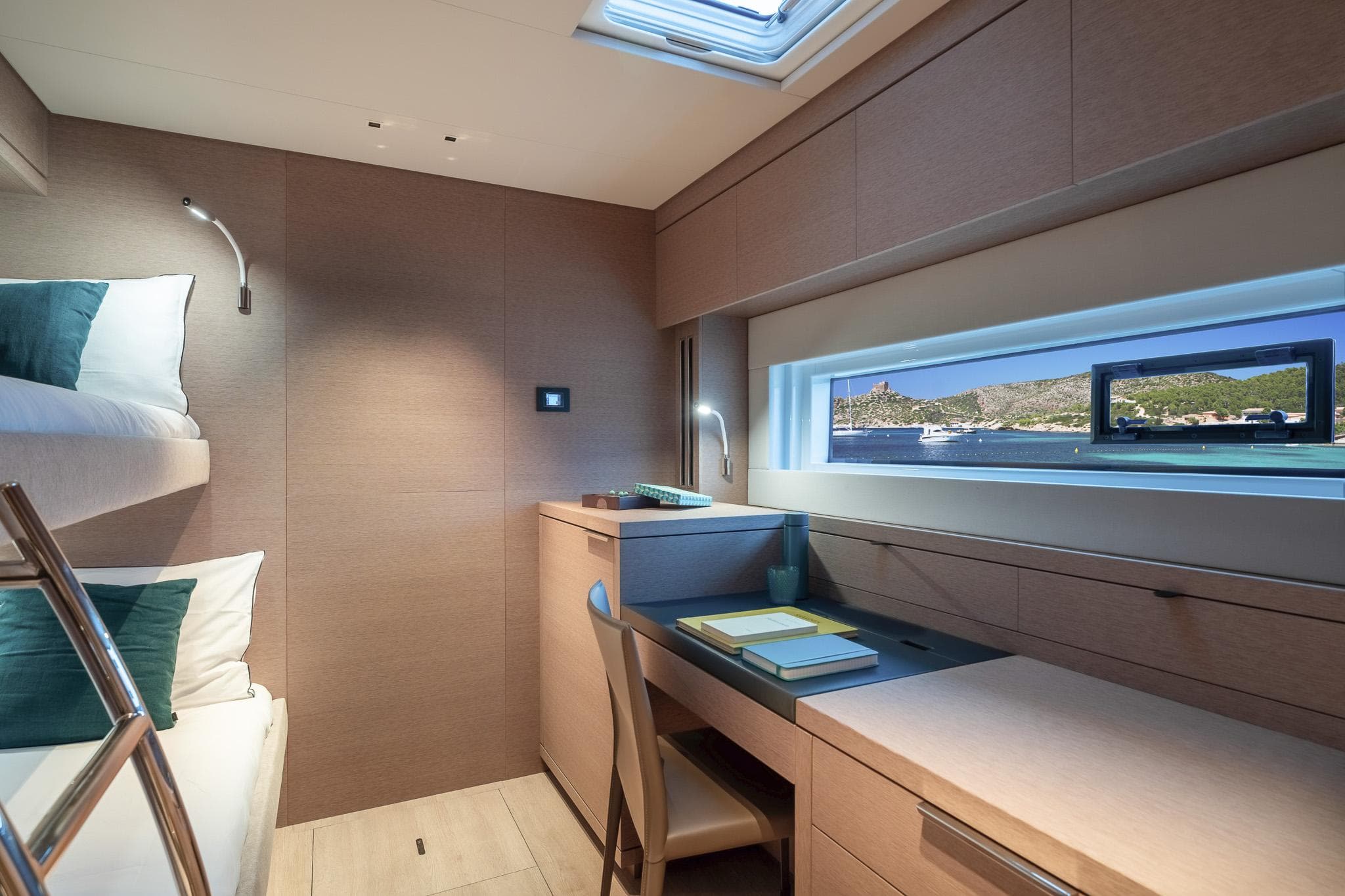 Luxurious cabin interior of 2025 Lagoon SIXTY 5 yacht with bunk beds and desk.