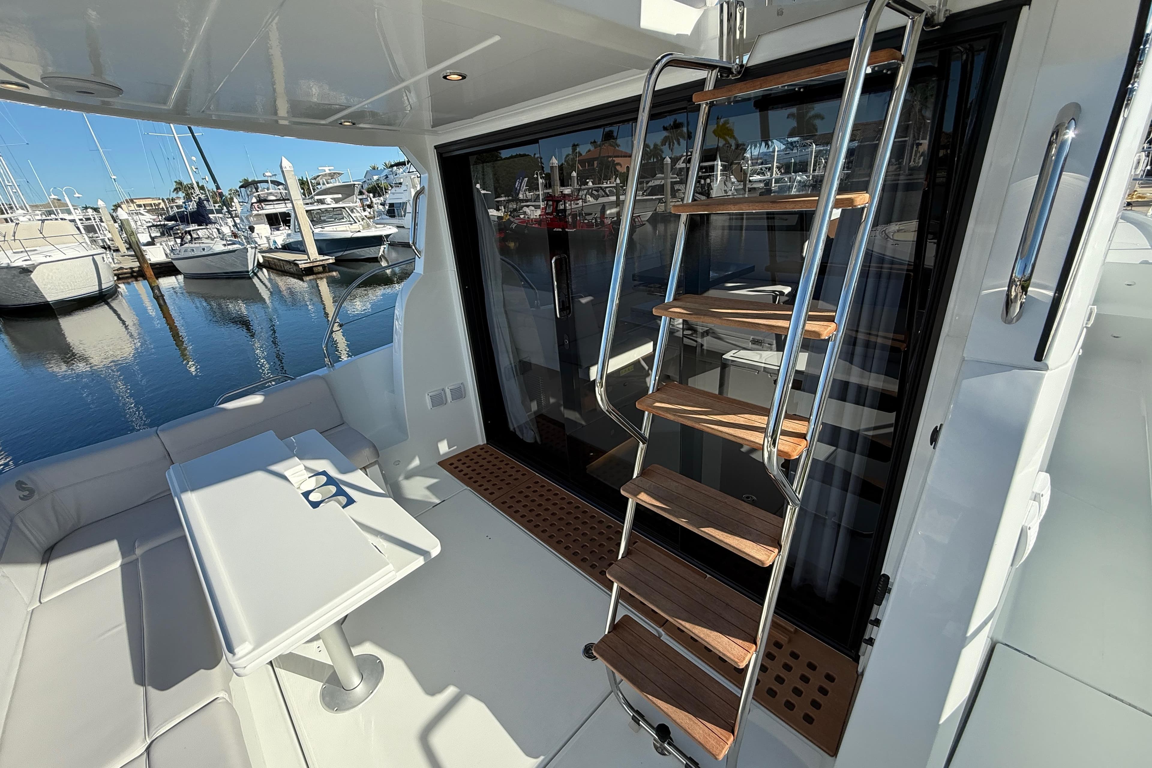 2026 Beneteau Antares 12 yacht interior with ladder and seating area at marina.