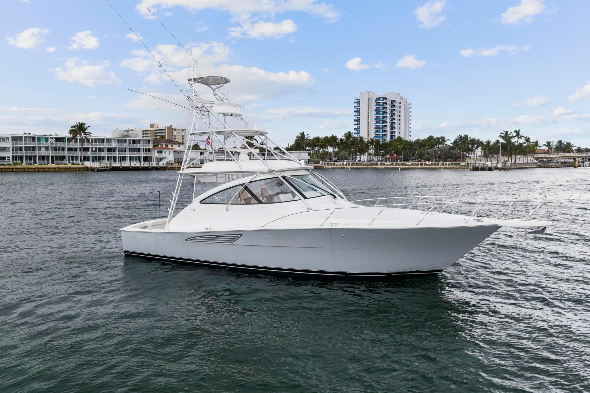 2018 Viking 44 Express yacht on water, with cityscape background.