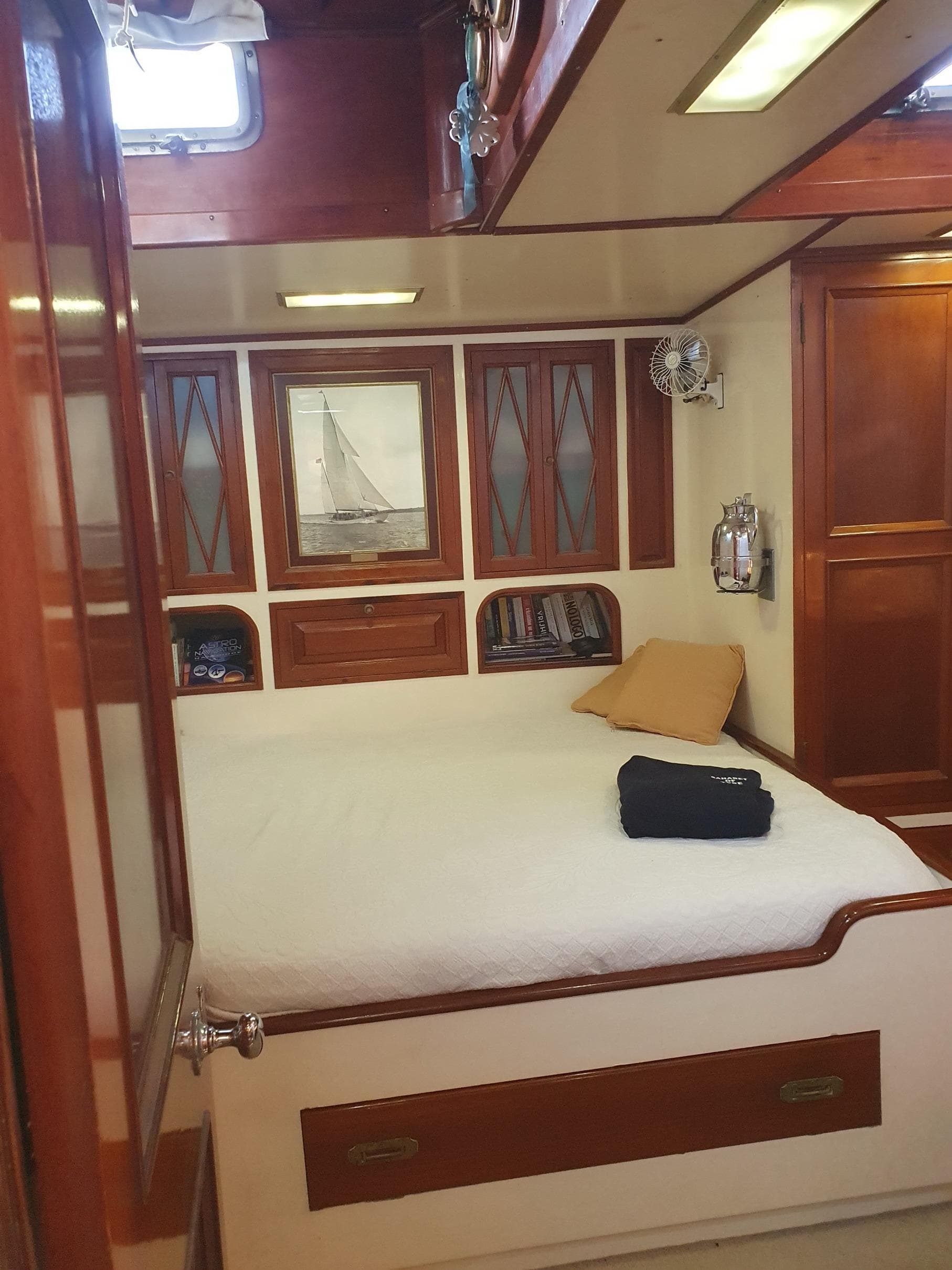 Interior of 1933 Camper & Nicholsons Classic 114FT Ketch, featuring a cozy cabin with wooden accents.