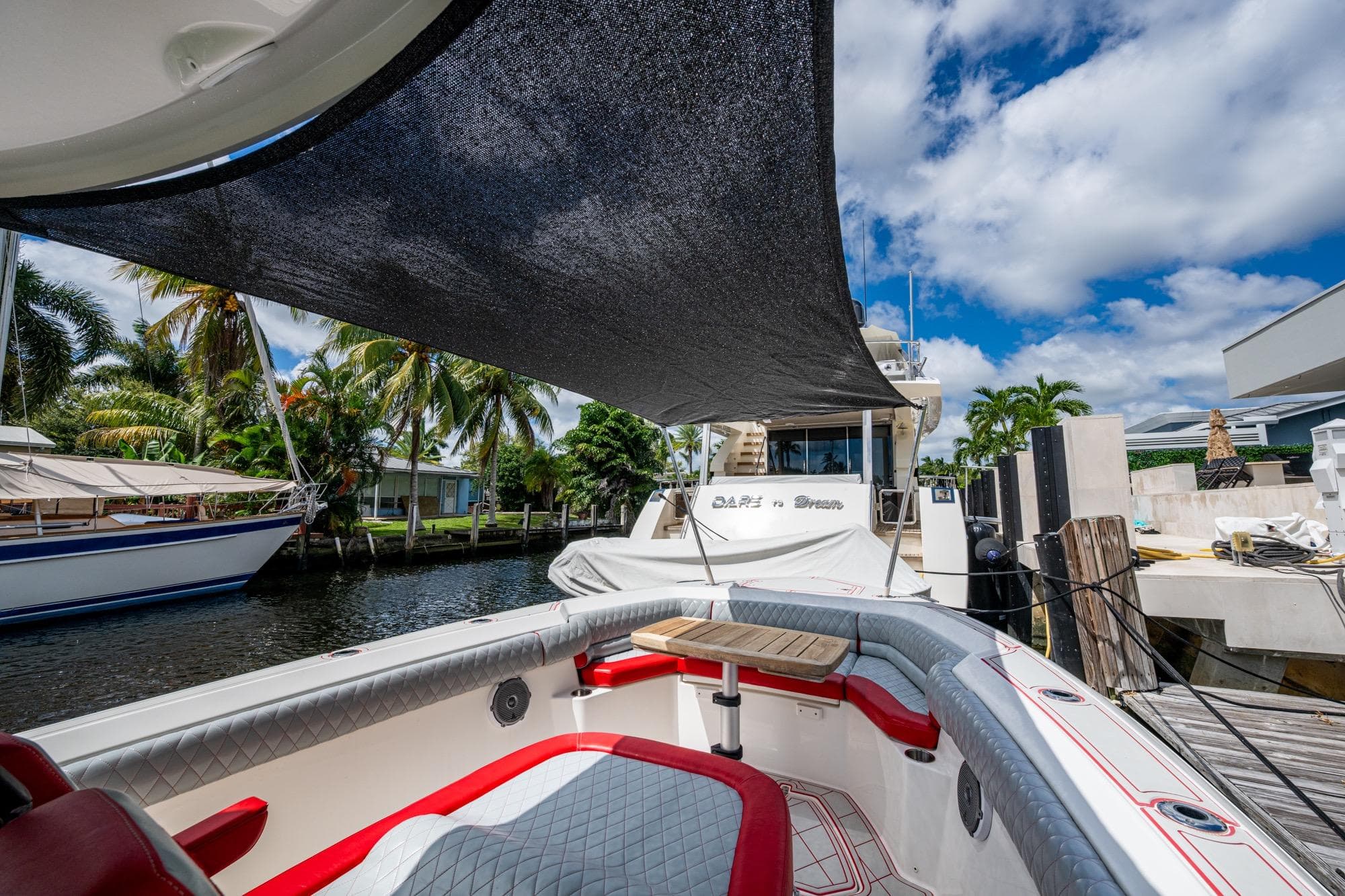 2018 Boston Whaler 330 boat docked, featuring shaded seating area and tropical surroundings.