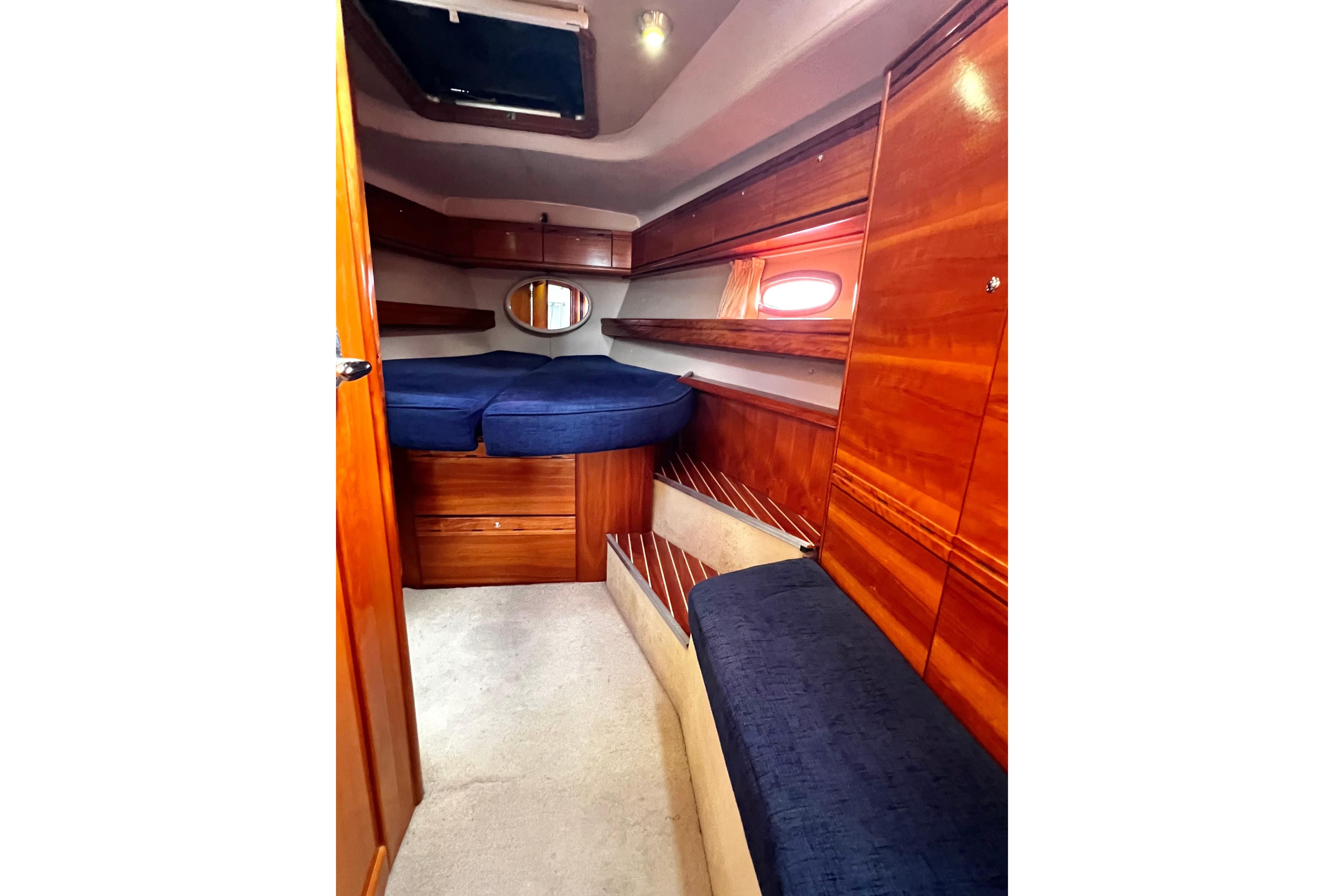 Interior of 2007 Bavaria 44 Vision yacht cabin with wooden finish and blue upholstery.
