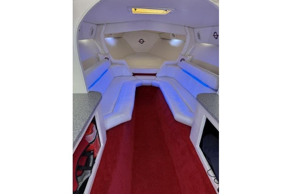 Interior of 2000 Fountain 47 Lightning boat with white seating and red carpet.