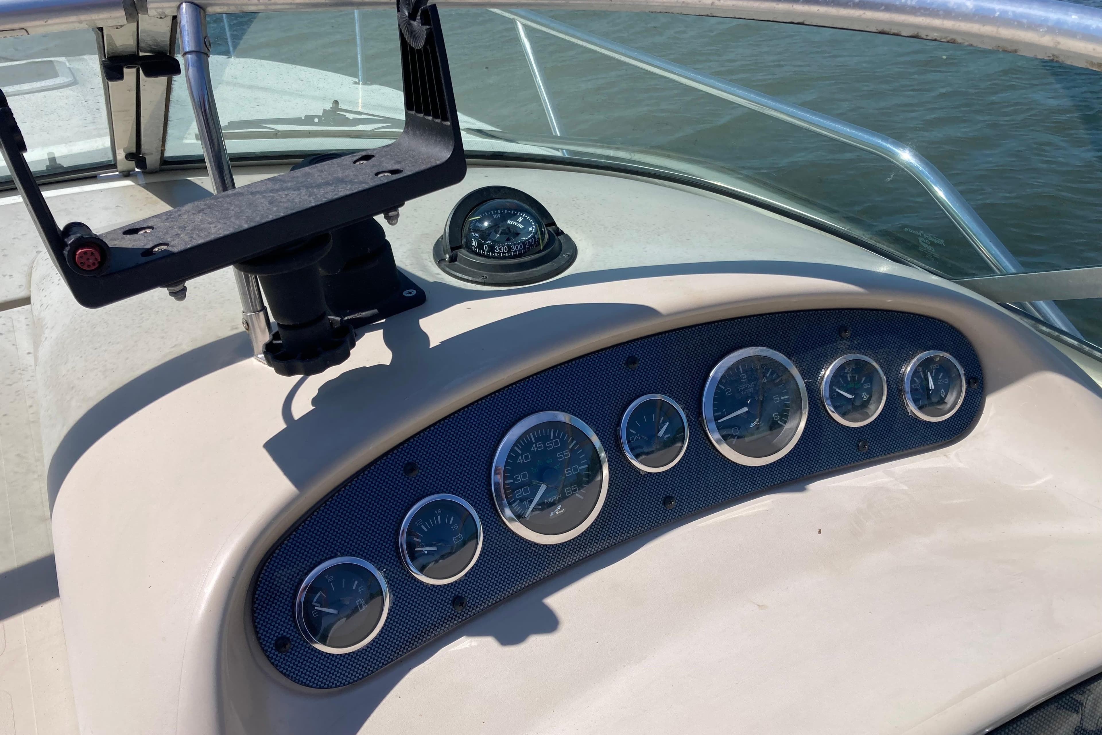 Dashboard of a 2002 Sea Ray Sundancer 260 boat with gauges and compass.