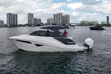 2025 NX Boats NX360 Sport Coupe on water with city skyline backdrop.