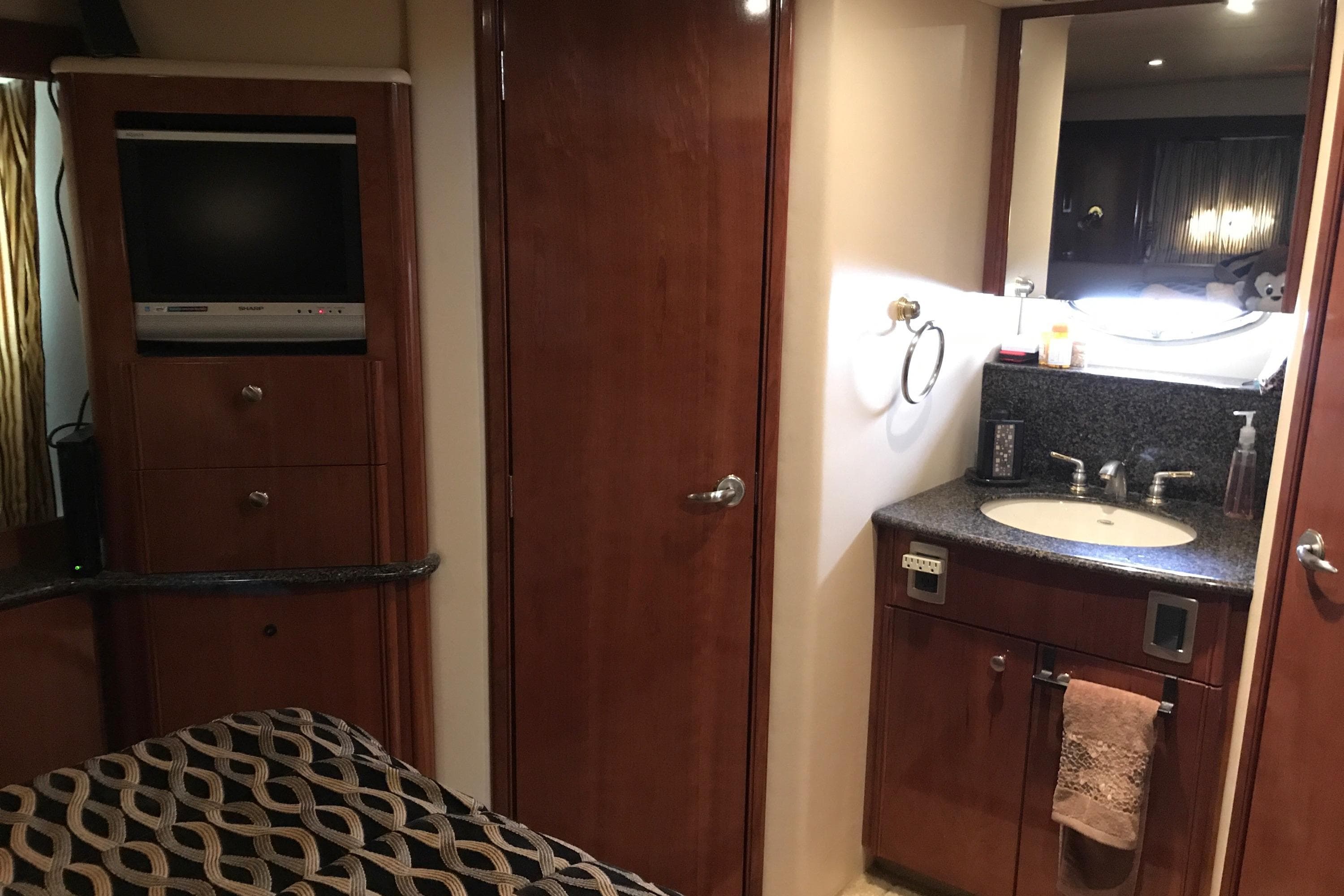 2006 Meridian 408 Motoryacht interior with TV, wooden cabinetry, and bathroom sink.