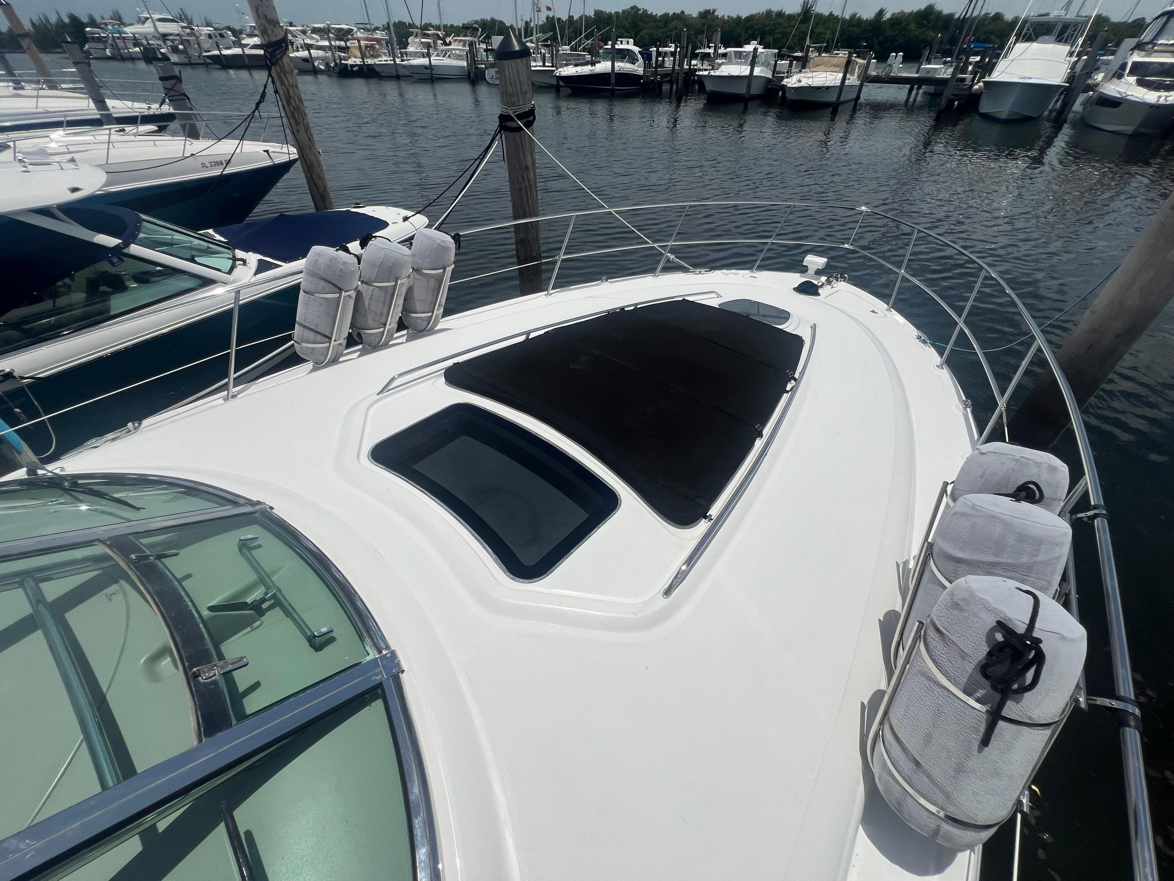 2005 Sea Ray 420 Sundancer yacht docked at marina, featuring sleek design and spacious deck.