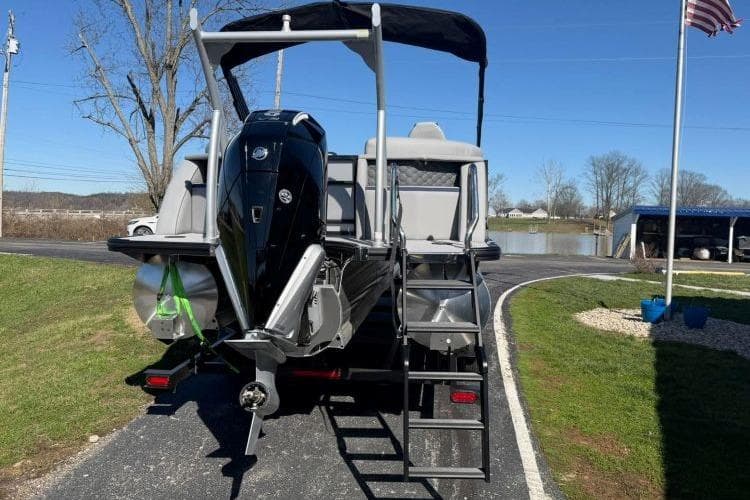 2026 South Bay 523RS pontoon boat with outboard motor, parked near a lake.