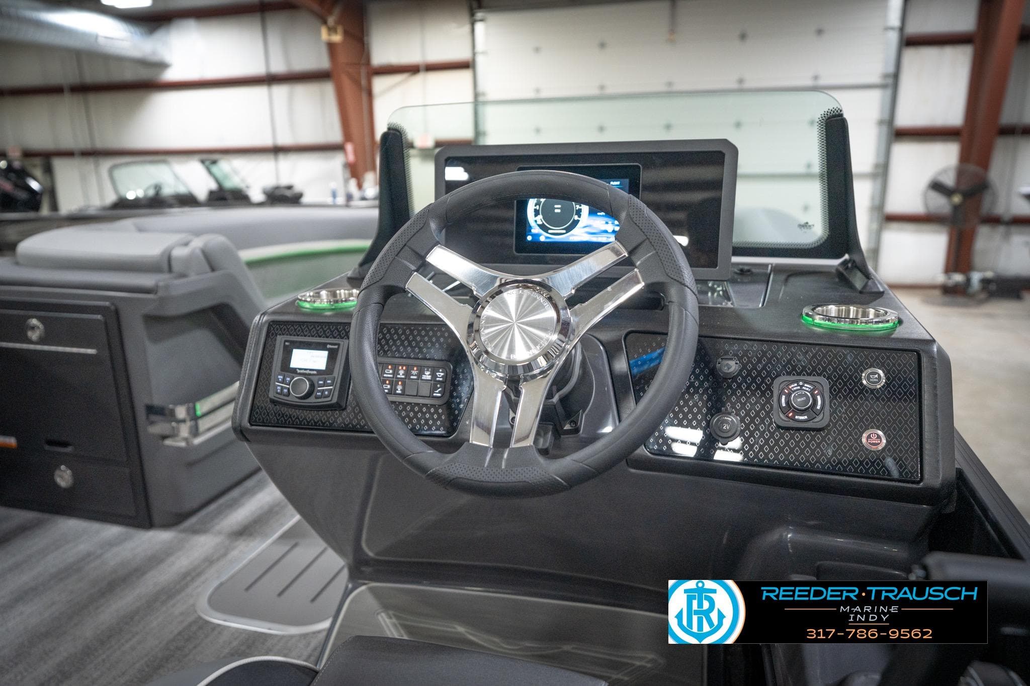 2026 Bennington 24 MFB boat dashboard with steering wheel and control panel in showroom.