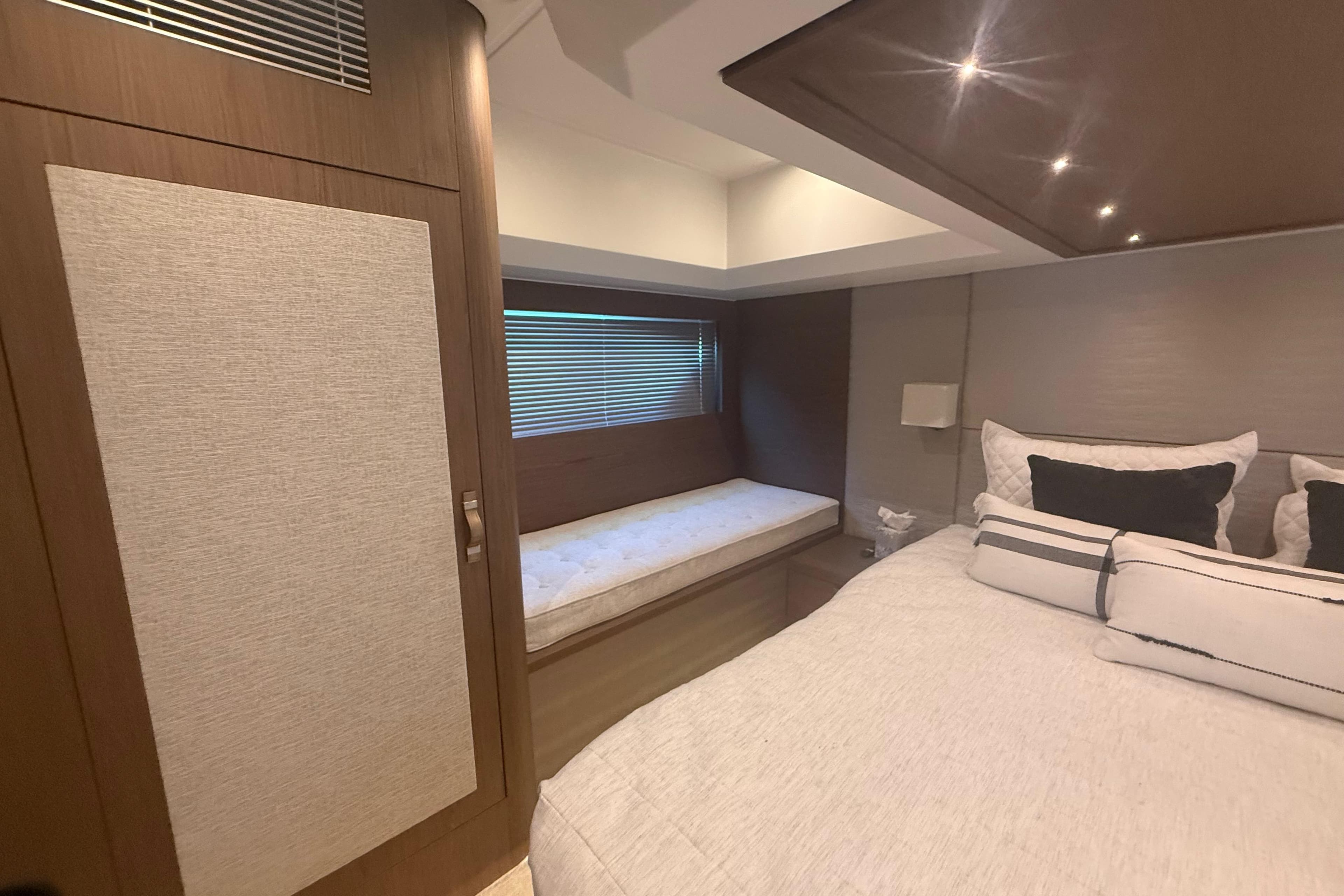 Luxurious bedroom interior of 2018 Beneteau Gran Turismo 50 yacht with elegant bedding and seating.