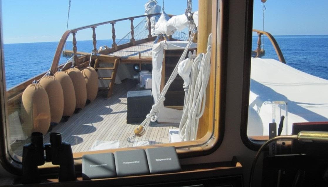 1925 Codecasa schooner deck view, featuring wooden railings and nautical equipment, sailing on open sea.