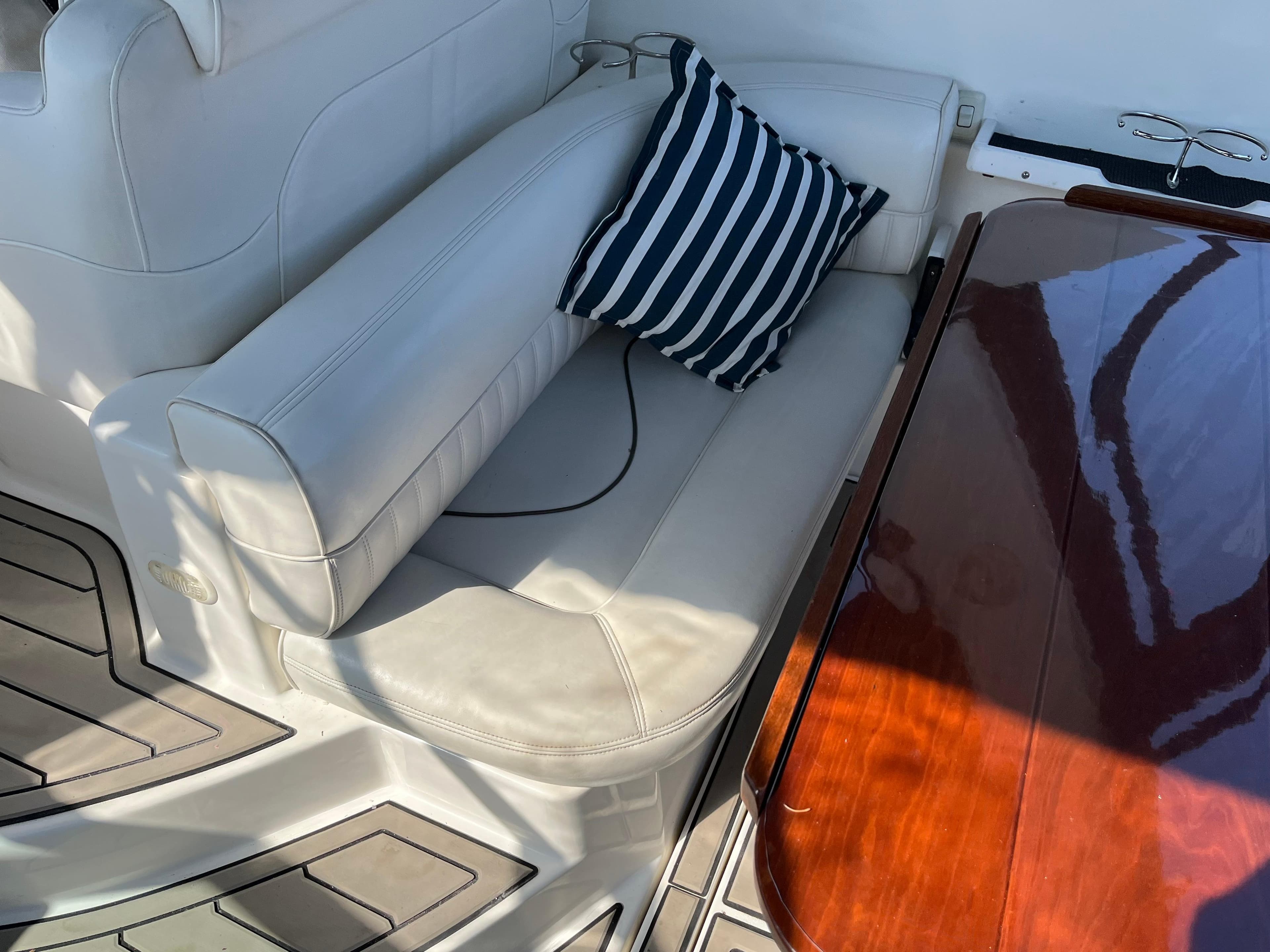 2001 Cruisers Yachts 2870 Express interior with white seating and striped pillow.