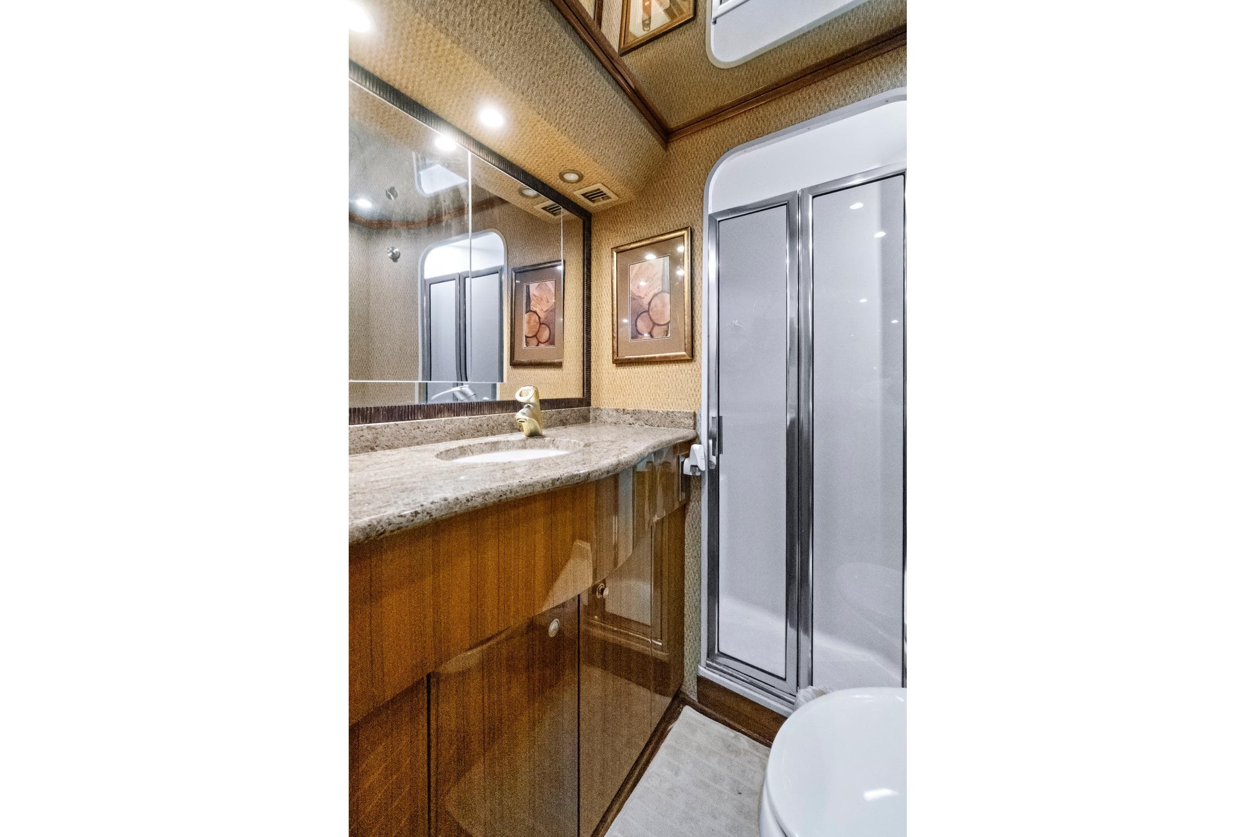 Luxurious bathroom in 2008 Viking 74 Enclosed Bridge yacht with granite countertop and shower.