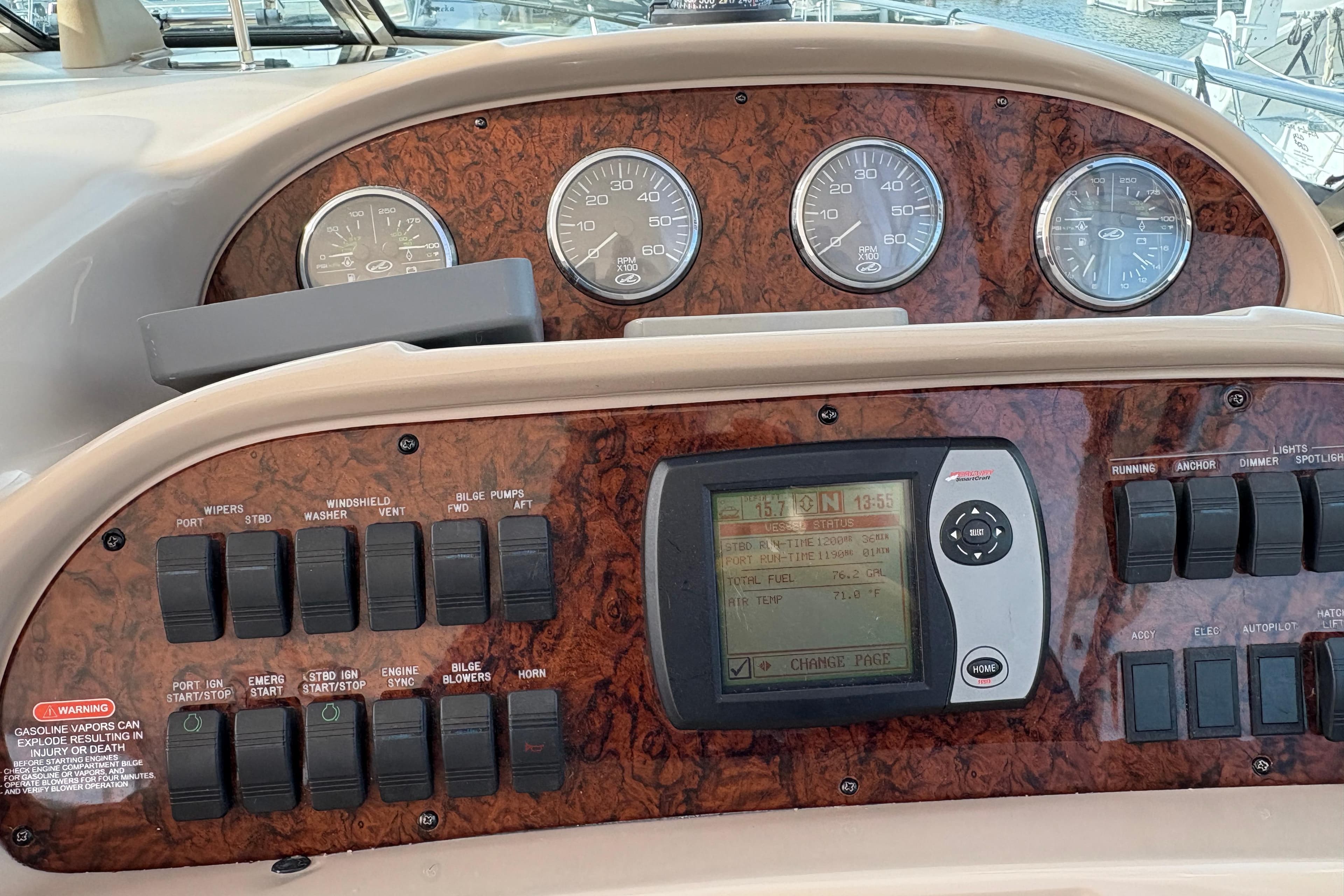 Control panel of a 2003 Sea Ray 360 Sundancer boat with gauges and switches.