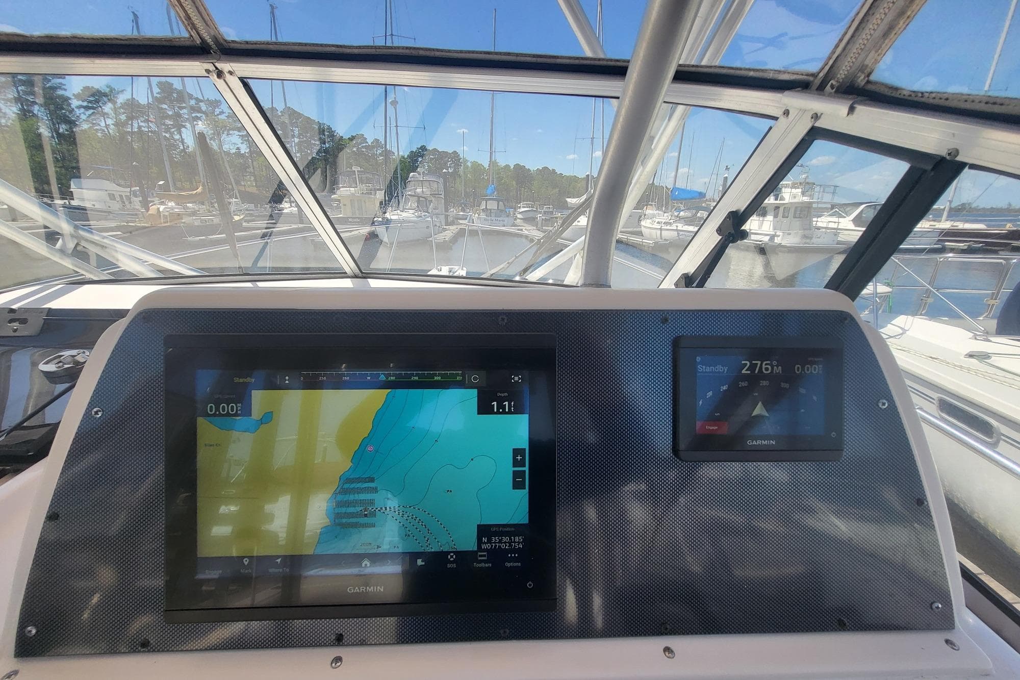 Grady-White Marlin 300 cockpit with navigation screens, docked at marina, 2004 model.