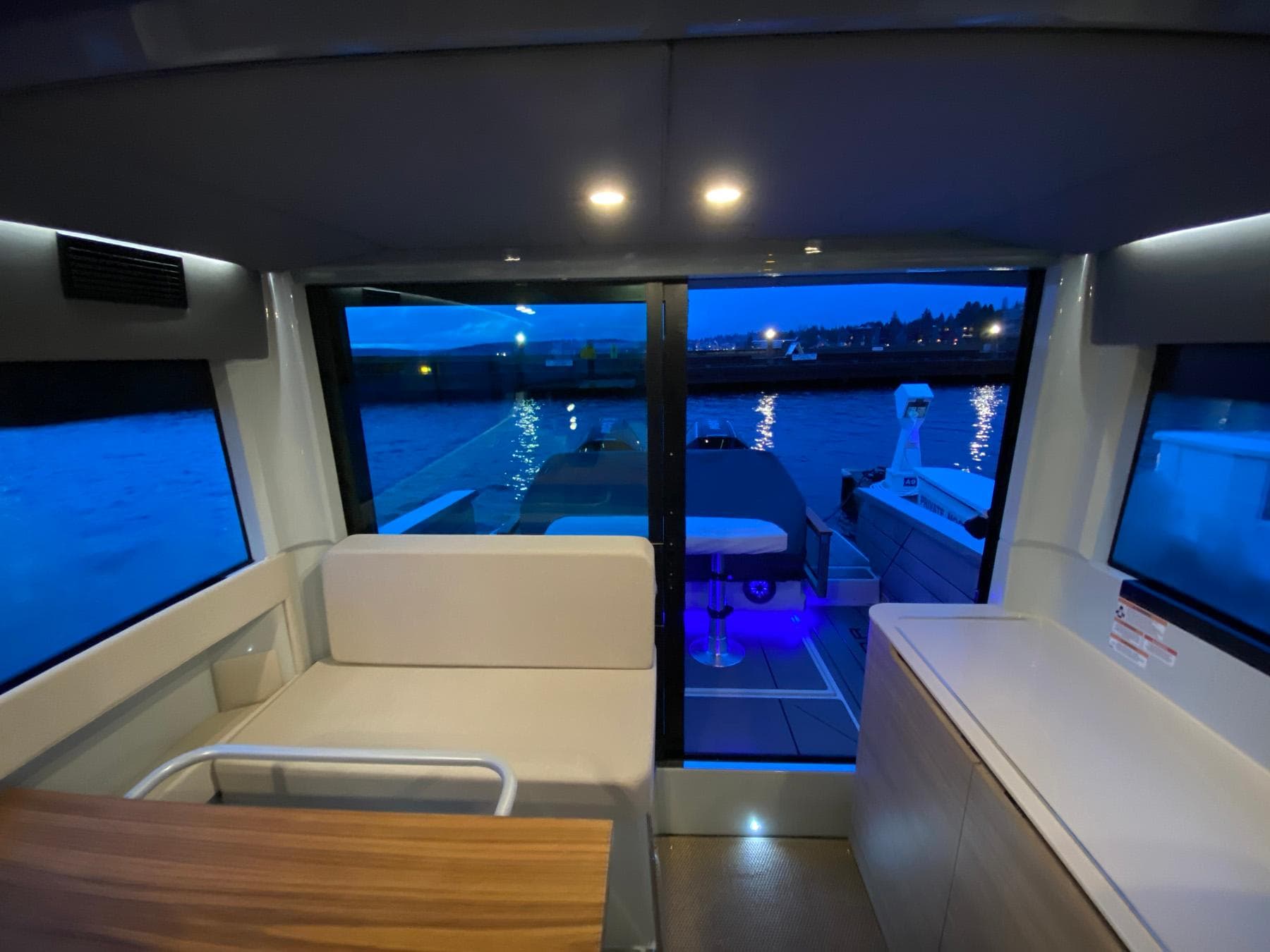 Interior view of 2025 Saxdor 320 GTC yacht at dusk, featuring modern seating and ambient lighting.