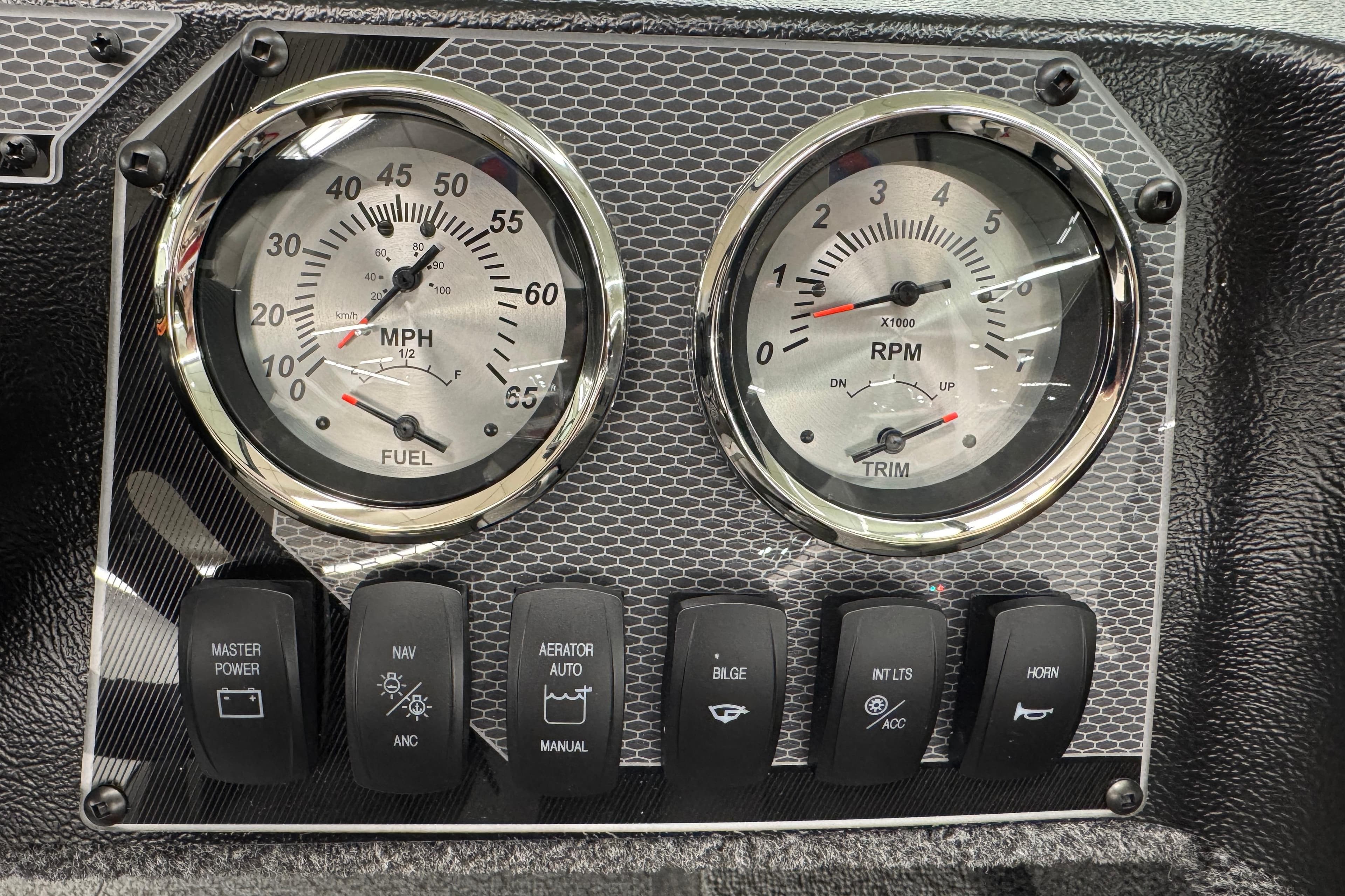 Dashboard of 2026 Lund 1650 Rebel XL Sport with gauges and control switches.