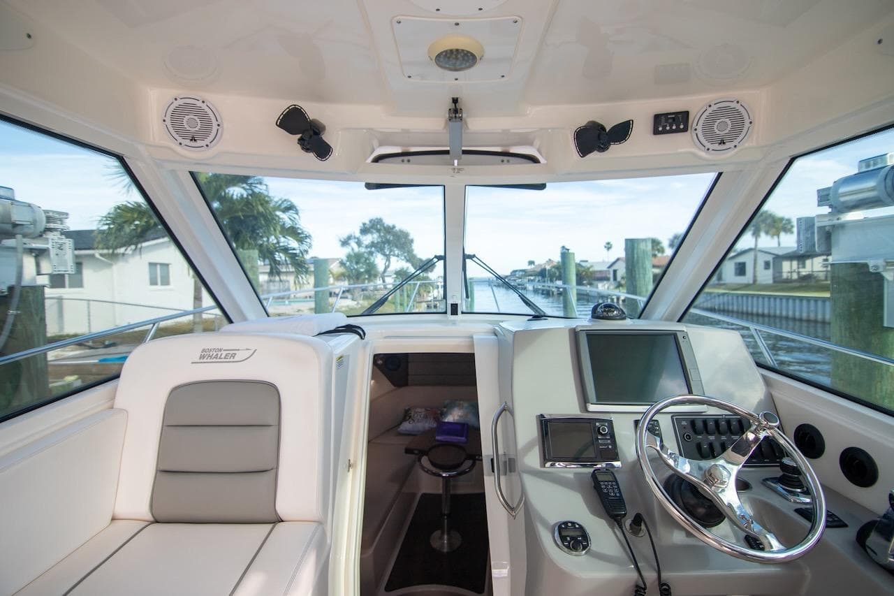 2014 Boston Whaler 315 Conquest boat interior with steering wheel and navigation equipment.
