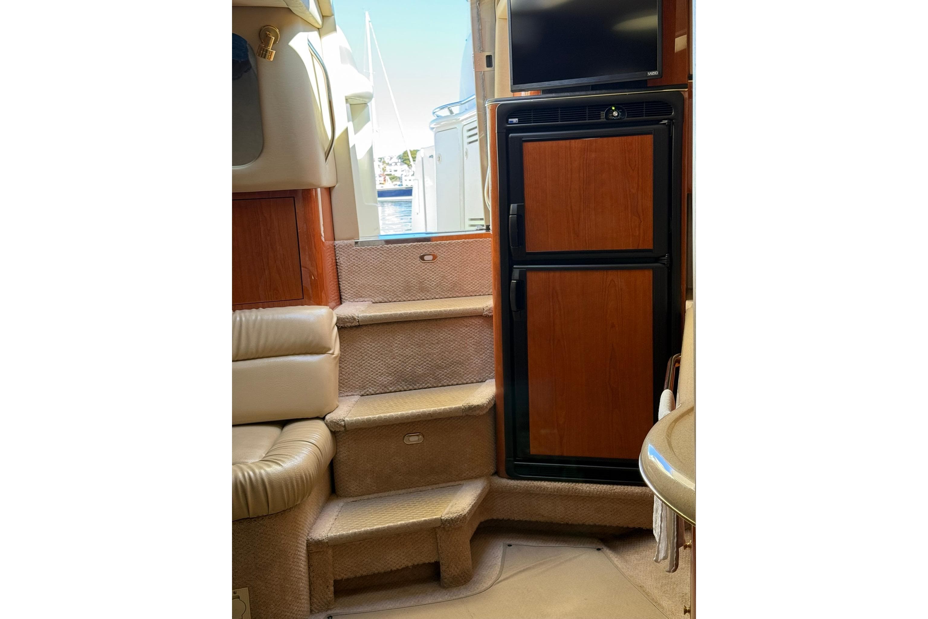 Interior of 2000 Sea Ray 410 Express Cruiser with steps and wooden cabinetry.