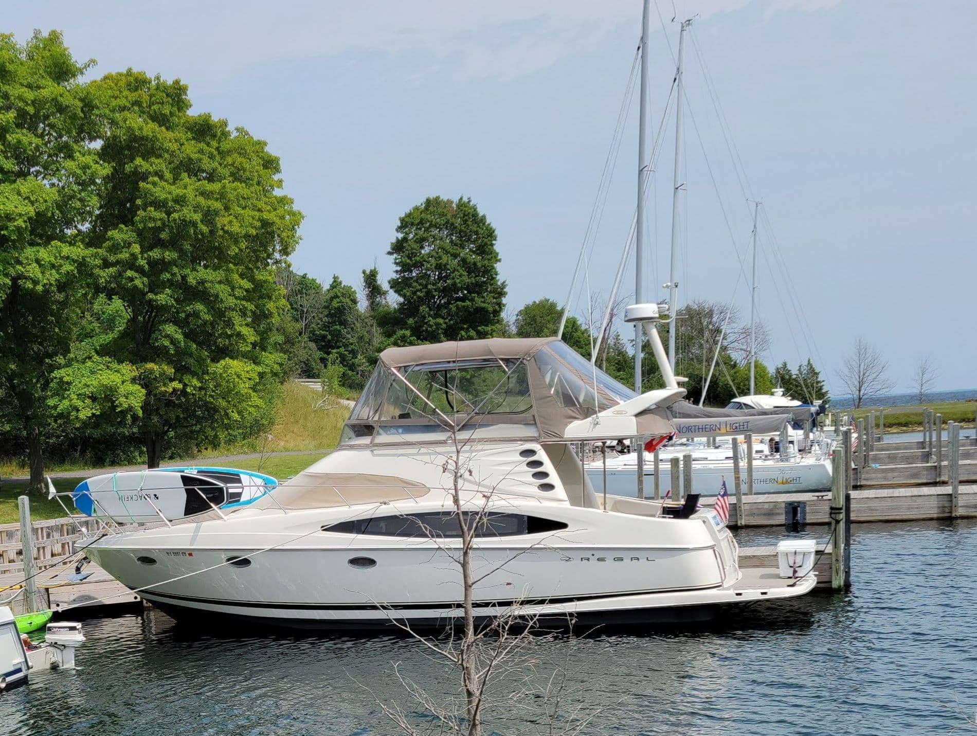 2001 Regal 3780 yacht docked in marina, surrounded by trees.