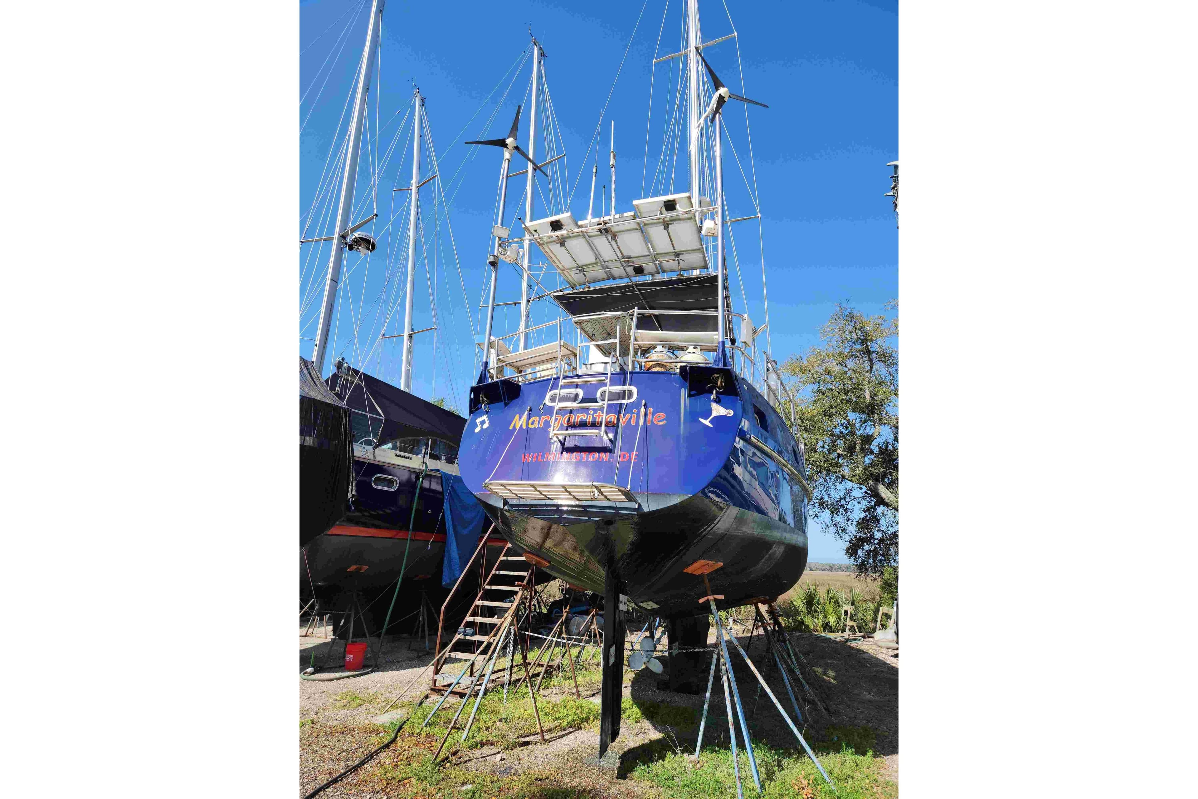 Sailboat "Margaritaville" on land, Custom Bruce Roberts 2000 model, under clear blue sky.