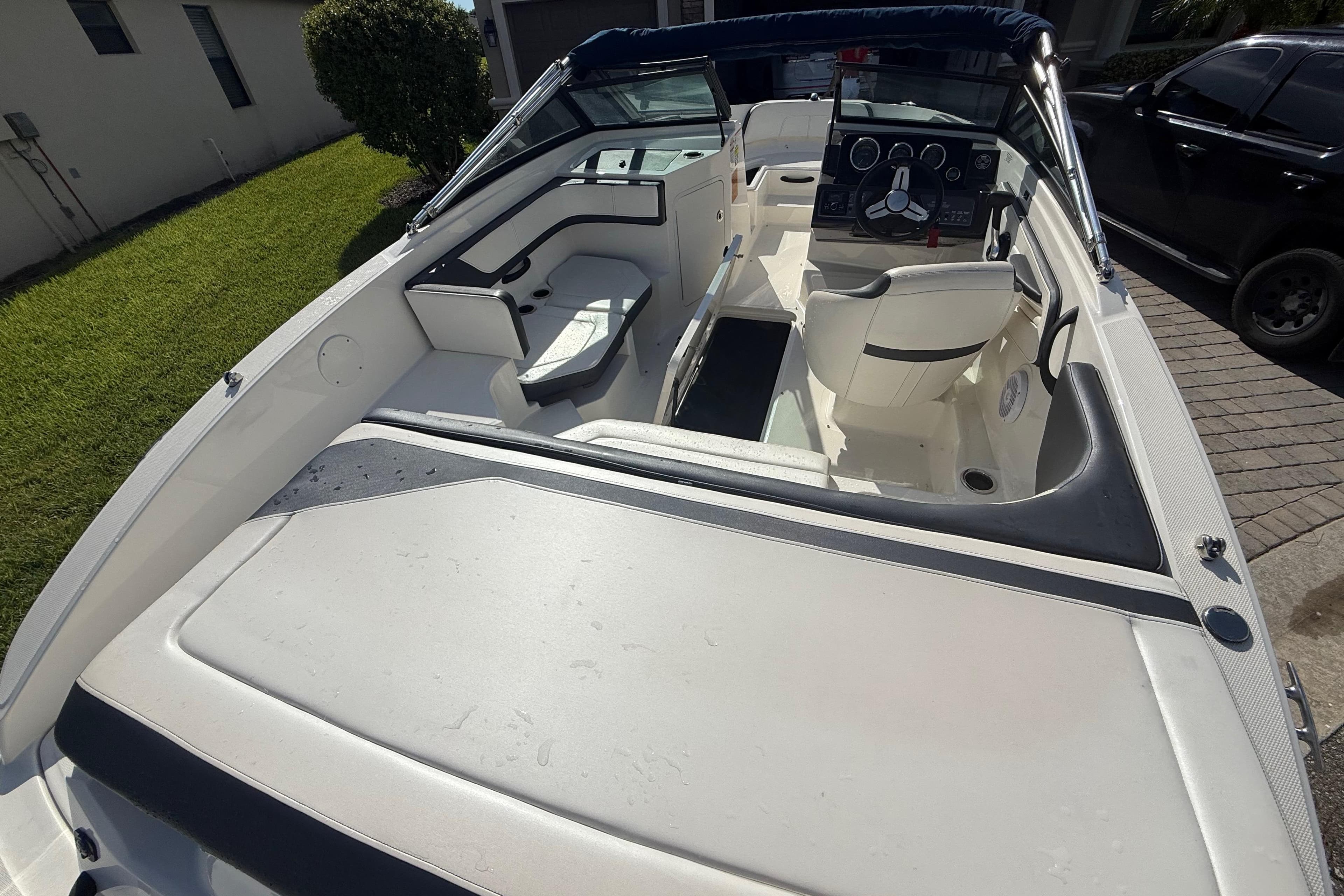 2018 Sea Ray SPX 190 boat interior with seating and steering wheel, parked outdoors.