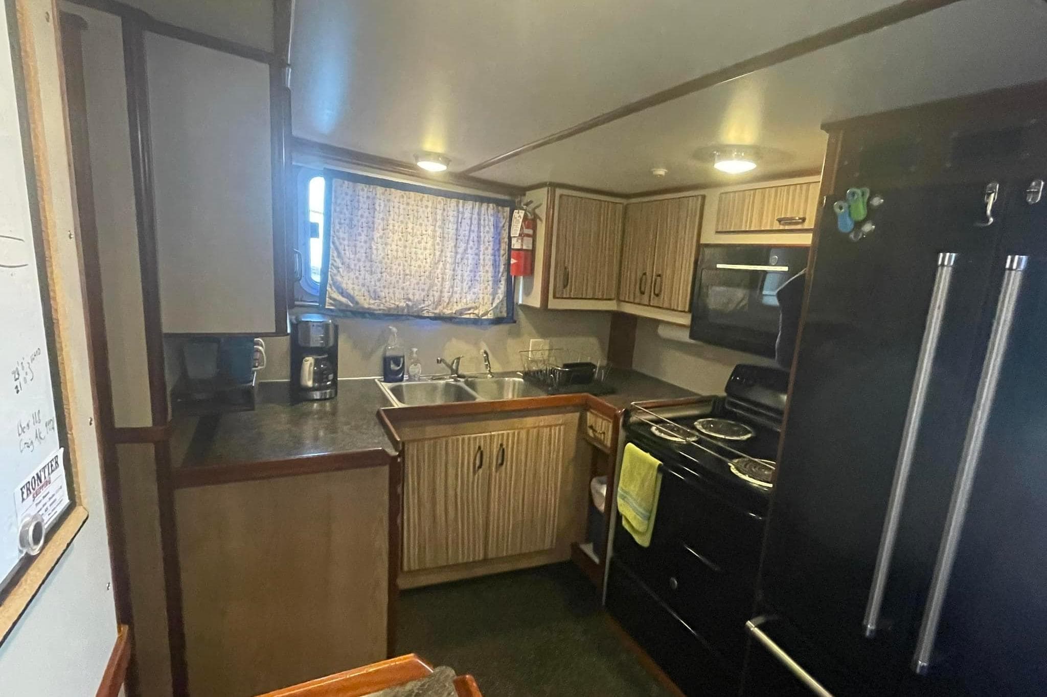 1973 Custom 58’ Steel Marco Seiner kitchen with modern appliances and wooden cabinetry.