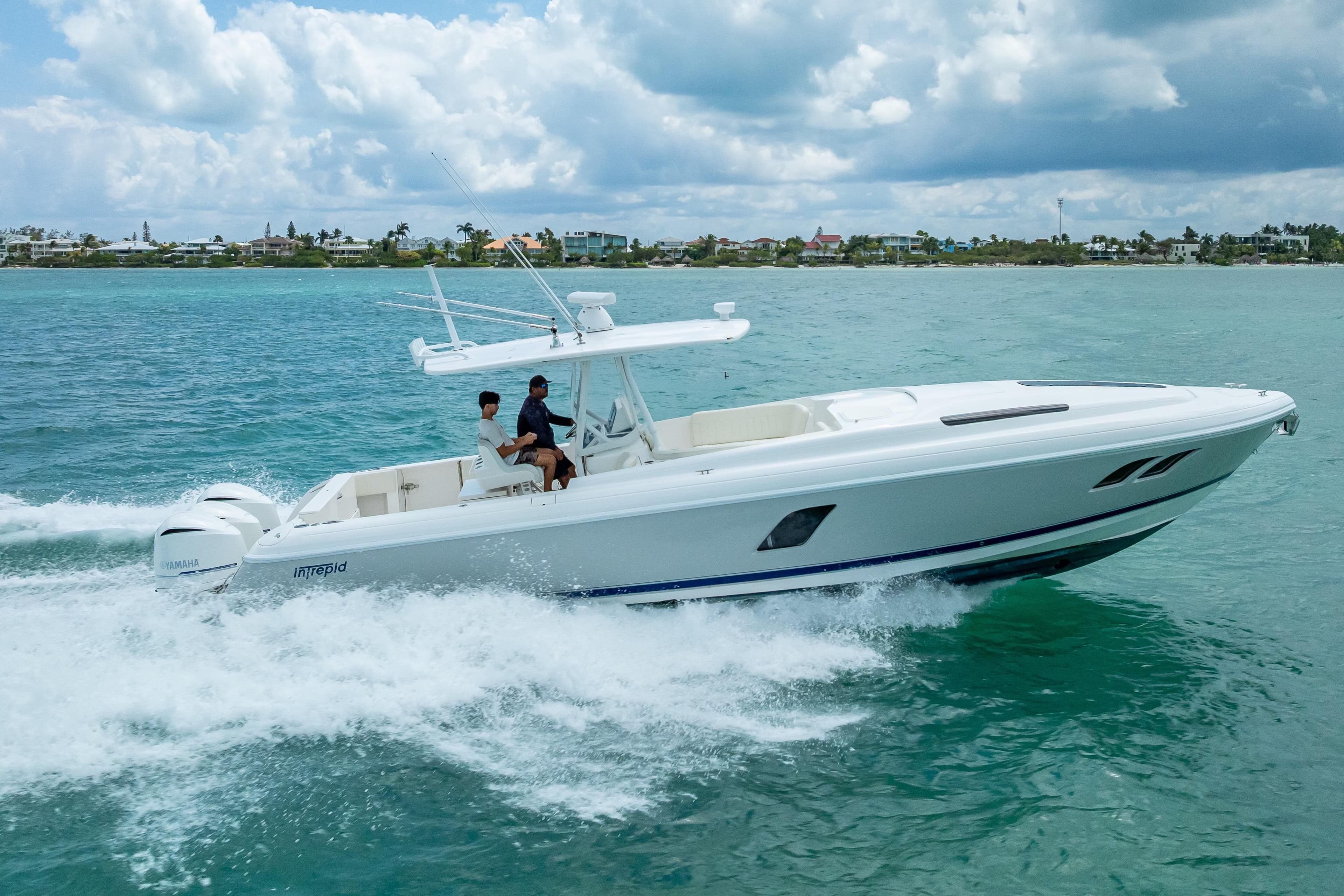 2015 Intrepid 400 Cuddy cruising on turquoise ocean waters under a cloudy sky.