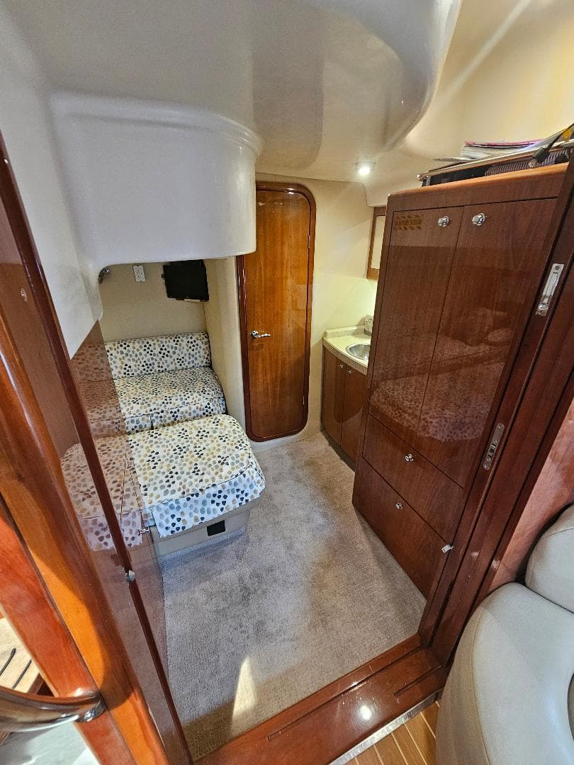 Interior cabin of 2007 Regal Commodore 4460 yacht with cozy seating and wooden cabinetry.