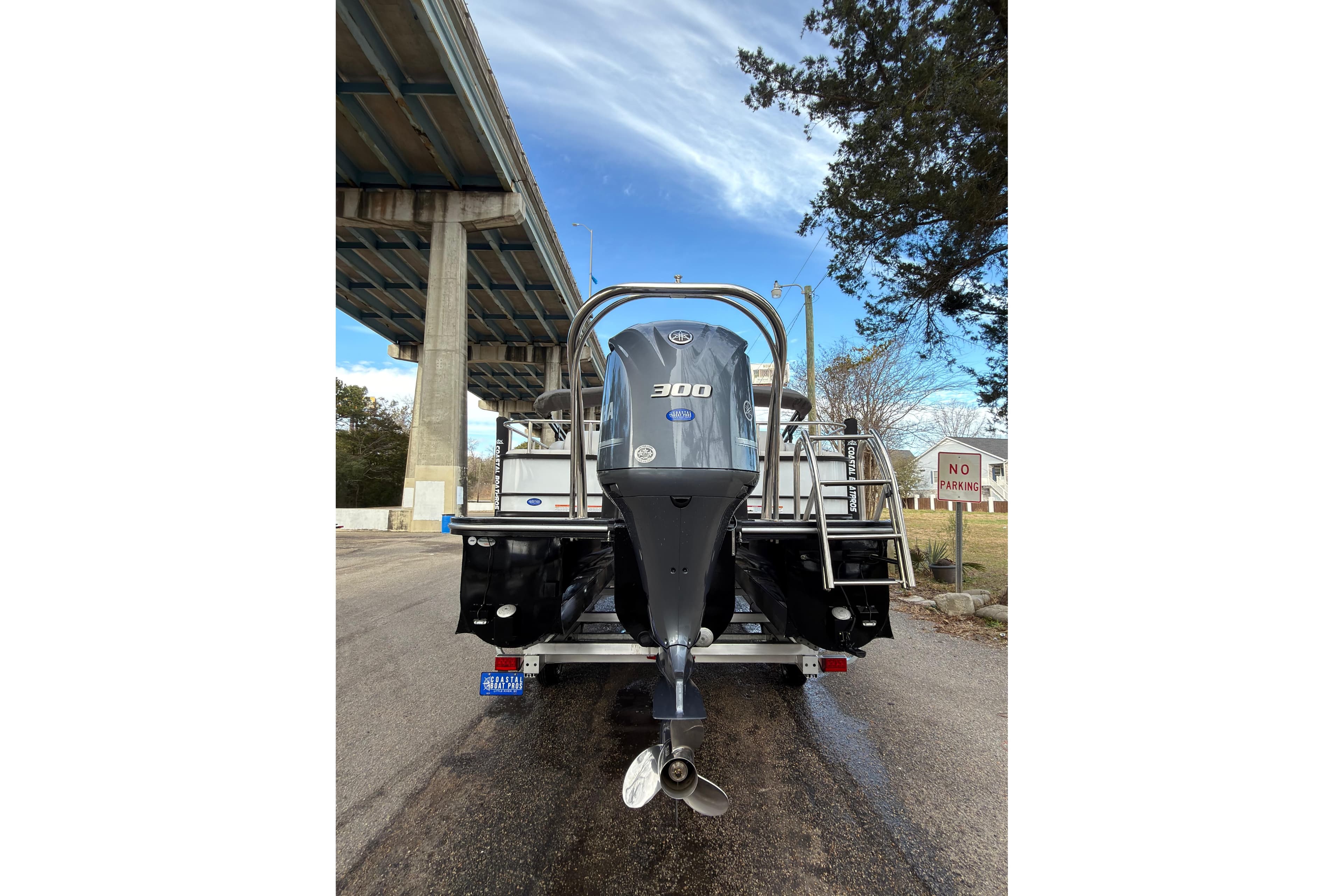 2025 SunCatcher ELITE SERIES 324 SS boat with powerful outboard motor, parked under a bridge.