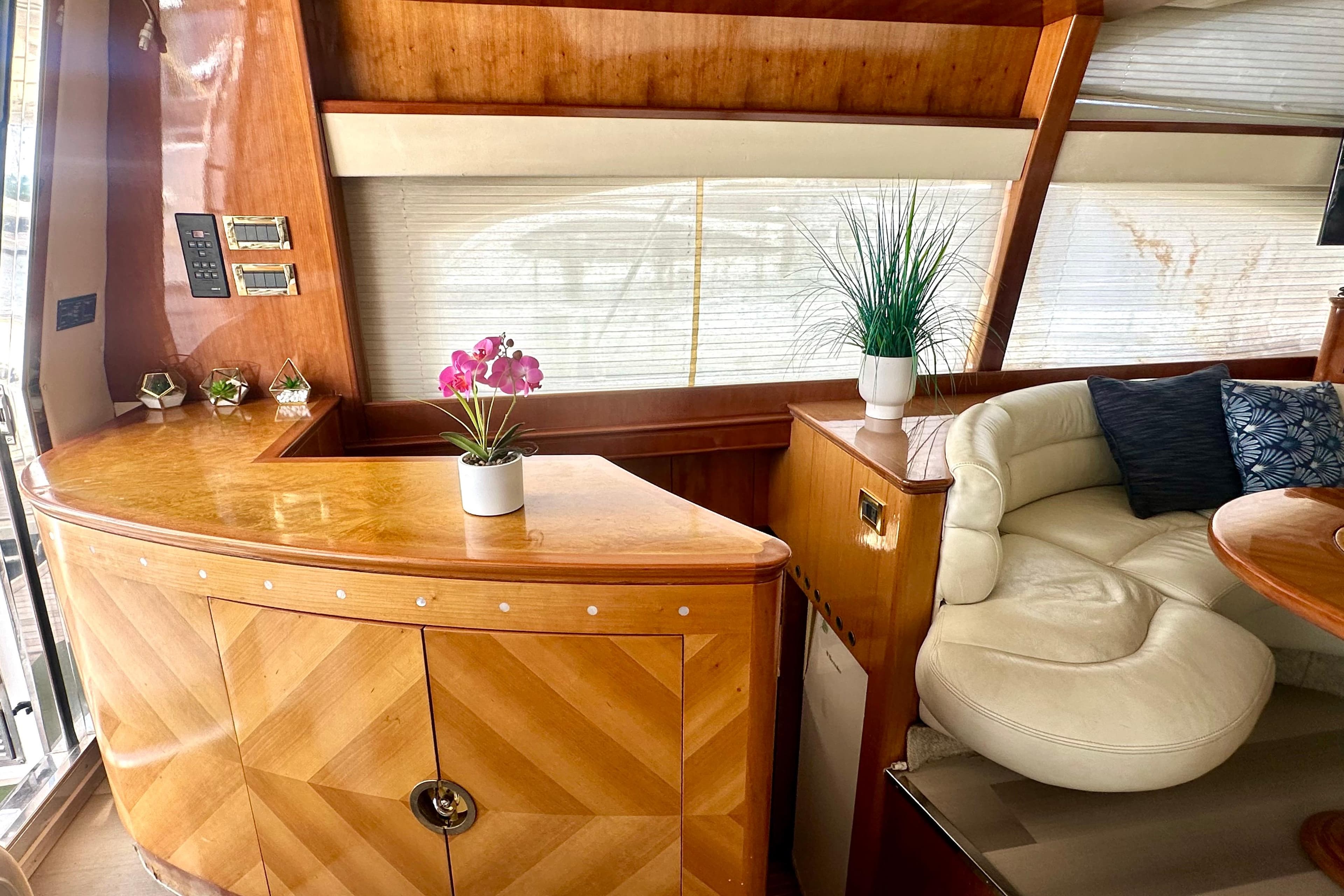 Luxurious interior of a 1999 Azimut 58 yacht with elegant wood finishes and plush seating.