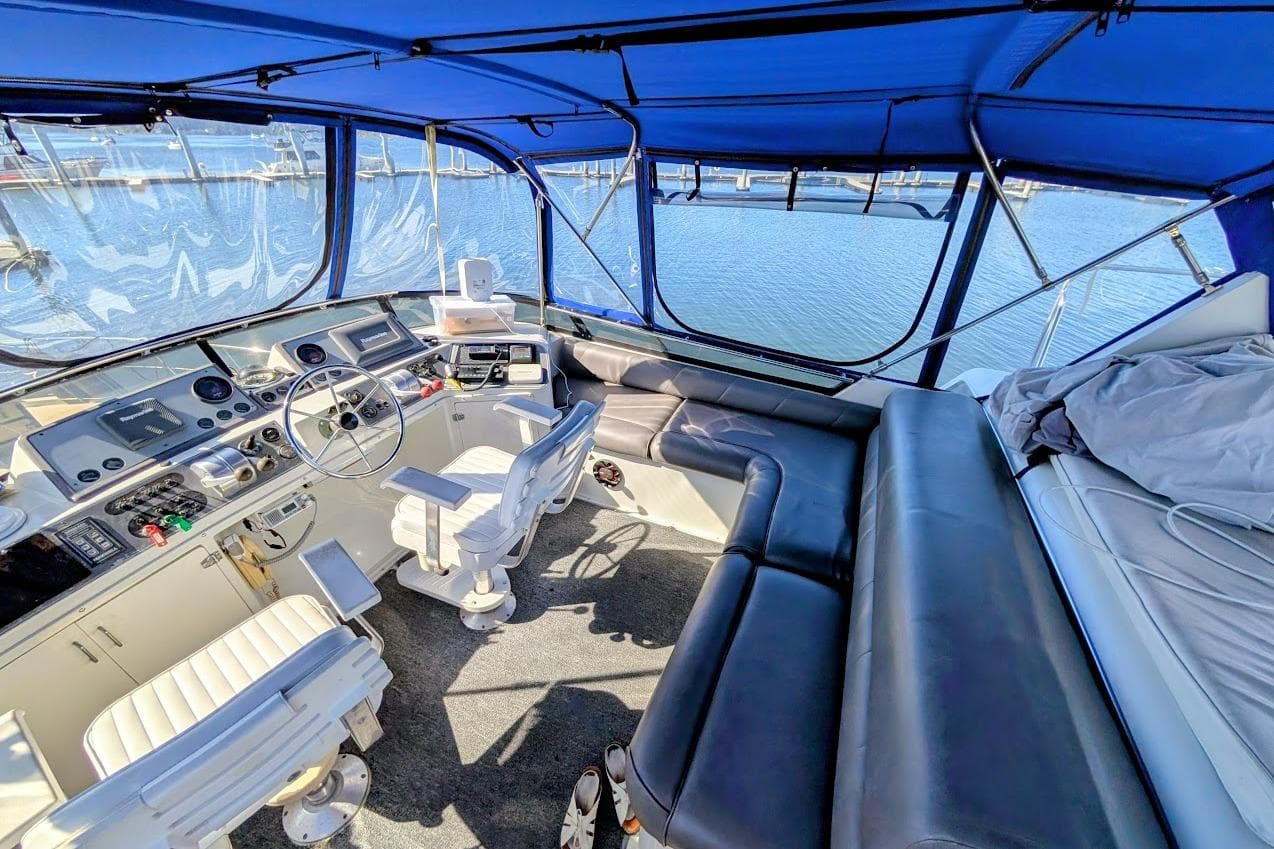 Interior of a 1990 Carver 55 yacht with blue canopy and leather seating.