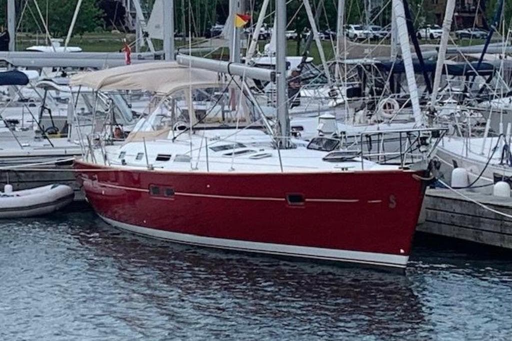 Red 2005 Beneteau Oceanis Clipper 423 sailboat docked in marina.