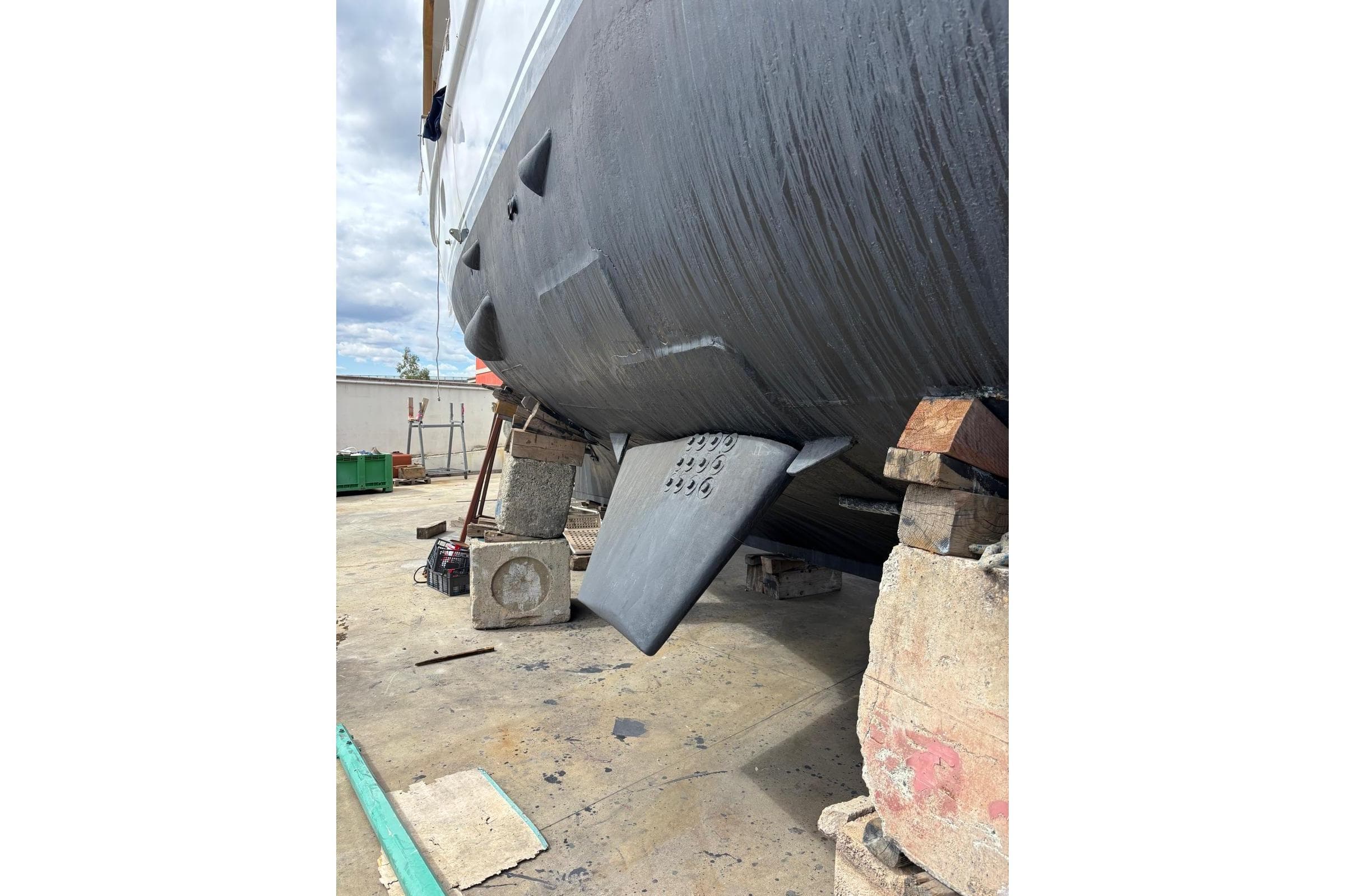 Codecasa 27m yacht from 1977 on dry dock, showing hull and stabilizer fin.