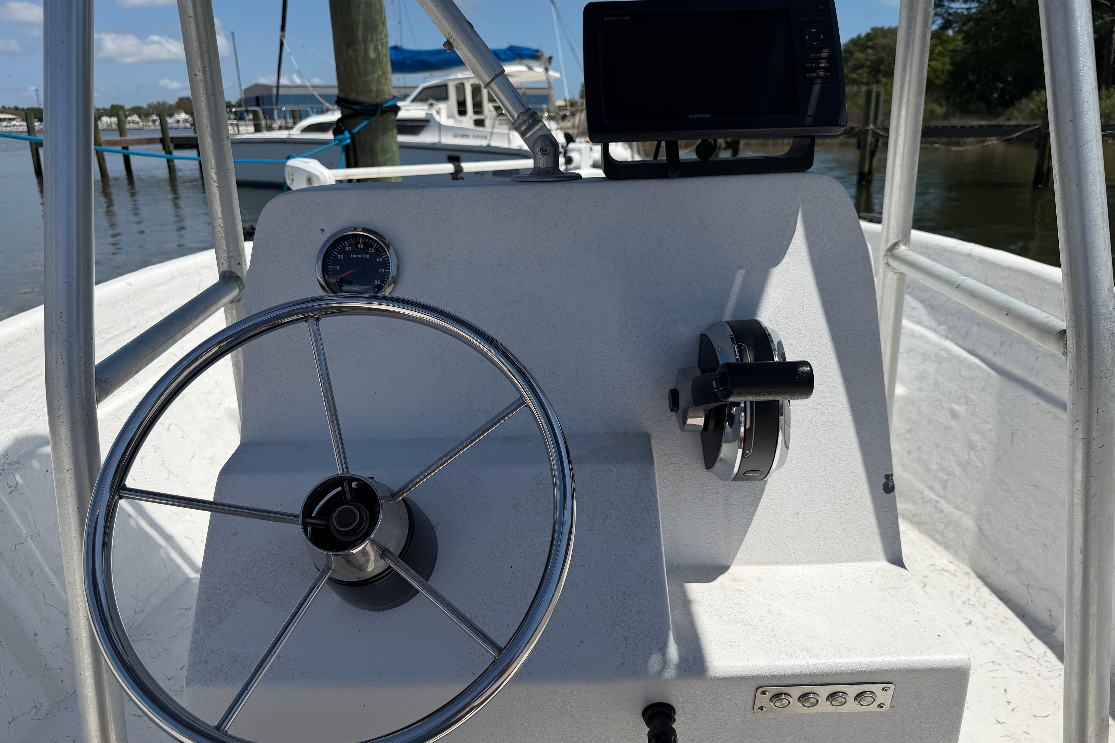 Center console of a 2002 Sea Chaser 2100 CC boat with steering wheel and controls.
