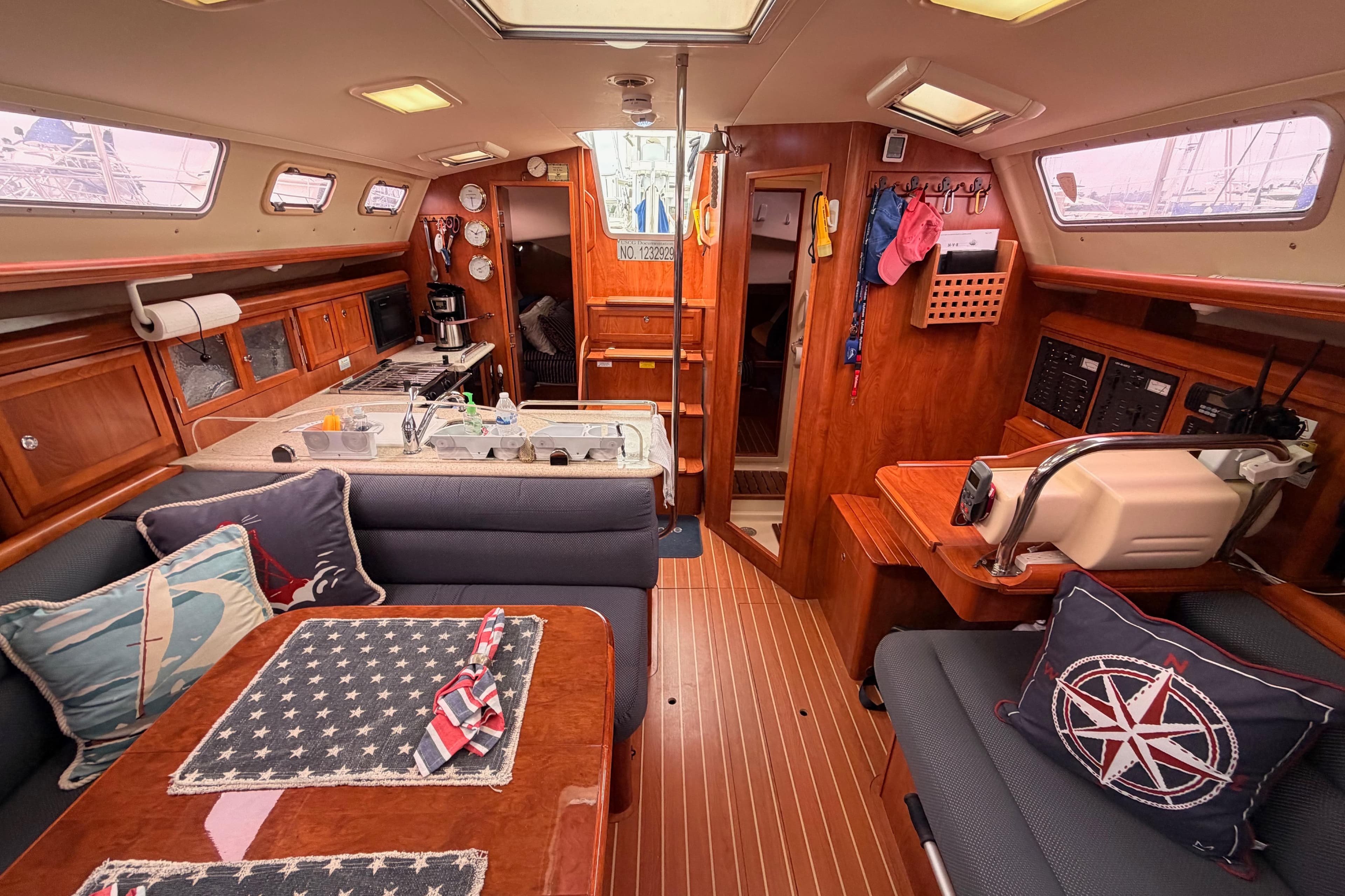 Interior of 2009 Hunter 38 sailboat with cozy seating, kitchen, and nautical decor.
