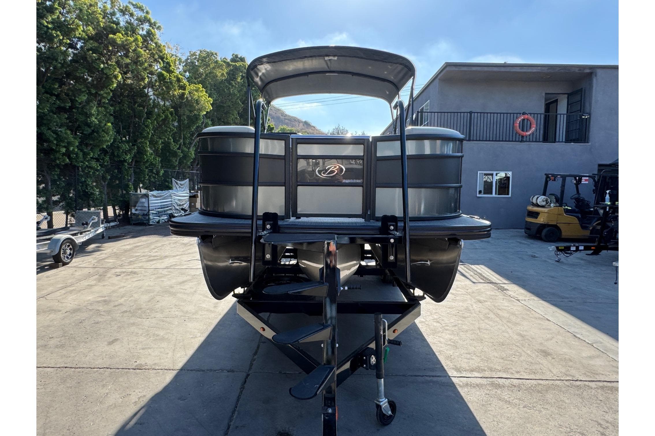 2026 Barletta Lusso 23UC pontoon boat on trailer, parked outdoors.
