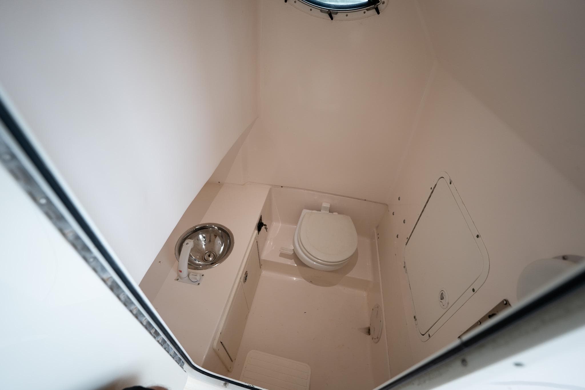 2007 Sea Hunt Triton 290 boat bathroom with toilet and sink.