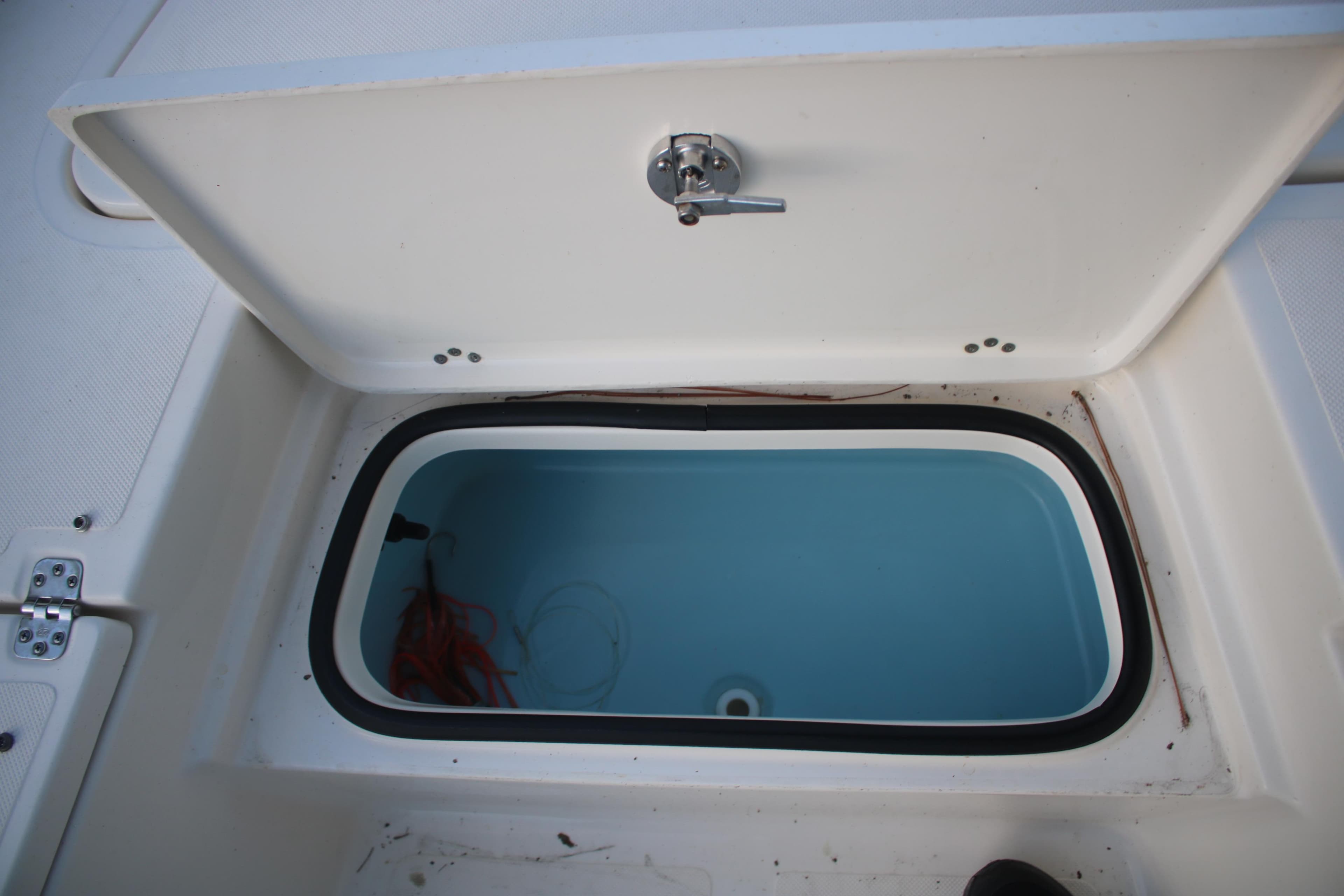 Open storage compartment on 2022 Pioneer 220 Bay Sport boat.