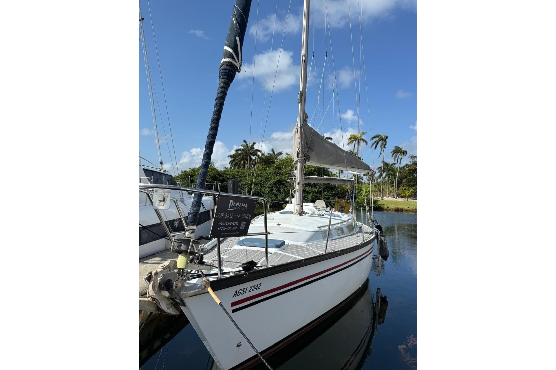 1982 Dufour 4800 sailboat docked, for sale in Panama, under clear blue sky.