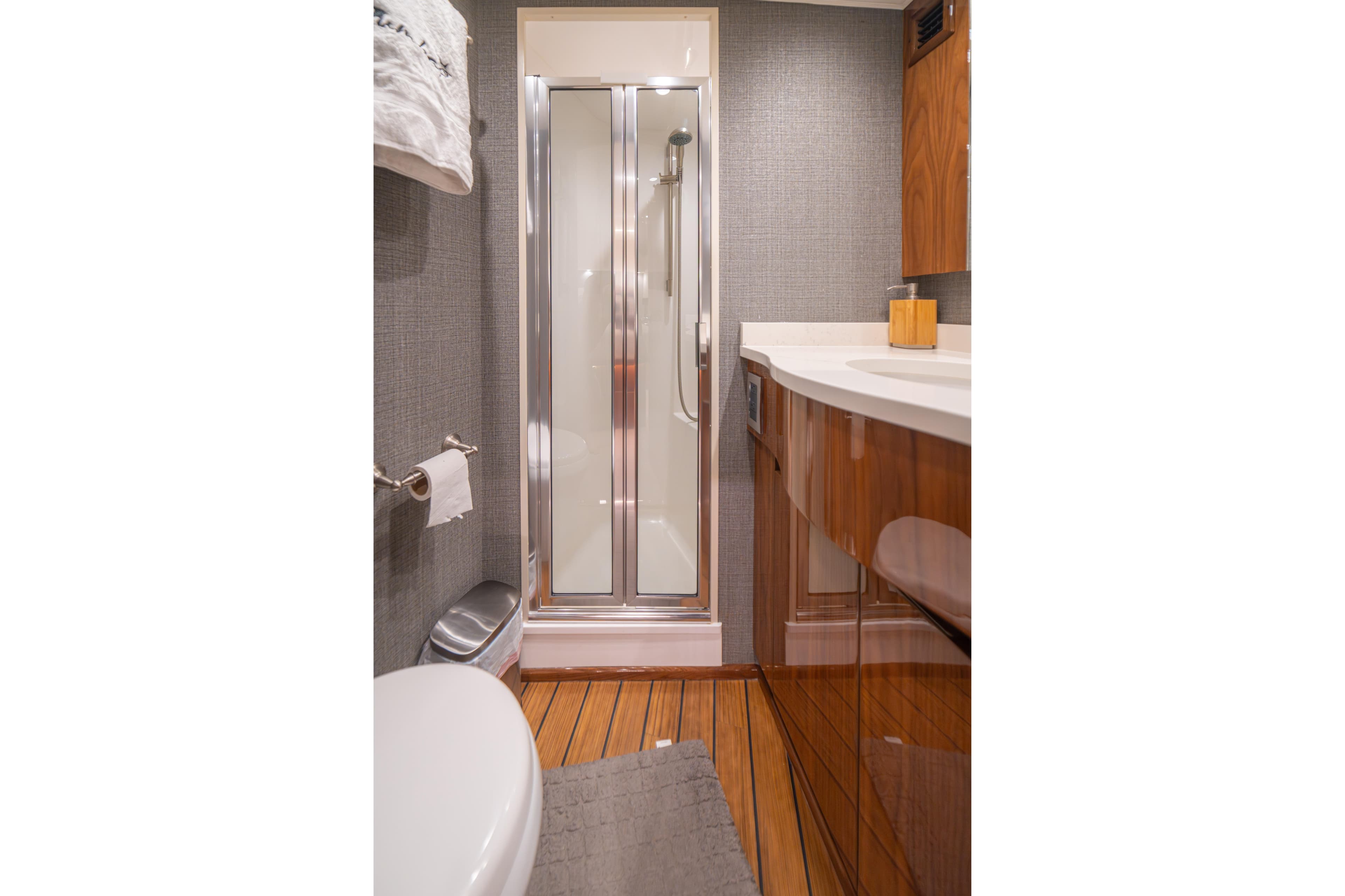 Luxurious bathroom in 2024 Viking 48 Convertible yacht with modern shower and wooden cabinetry.